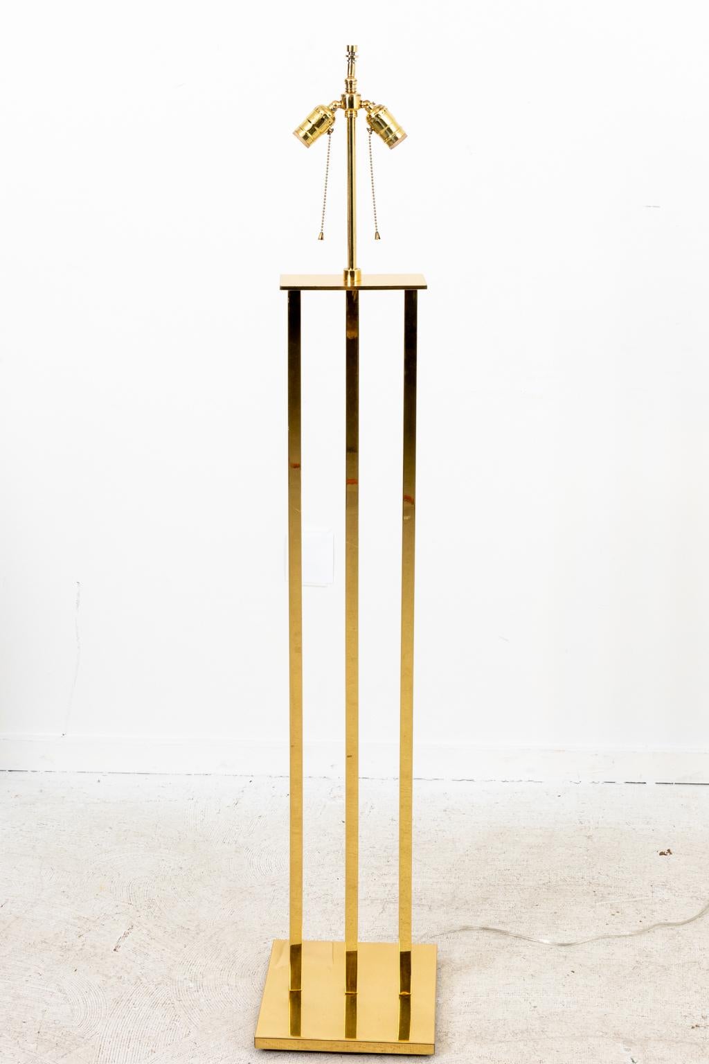 Circa 1970s Mid-Century Modern brass three tiered column floor lamp with double socket on a square base. Made in the United States. Please note of wear consistent with age including one small pin point dent to base and a few minor scratches.