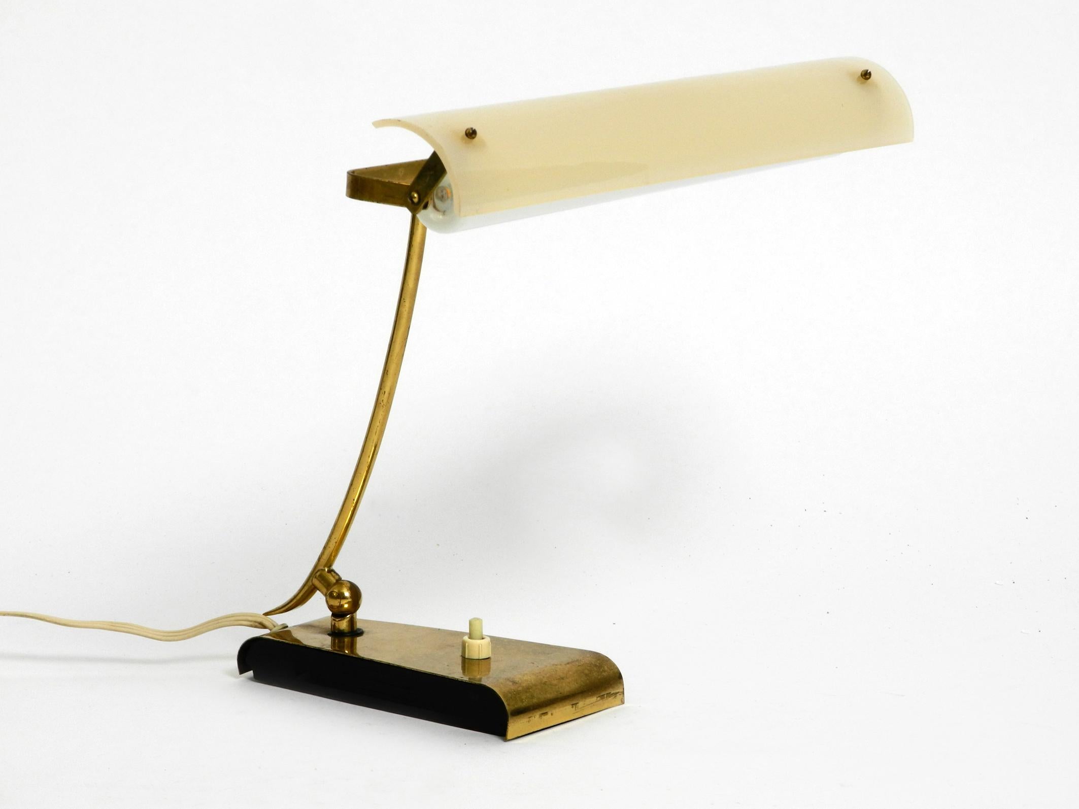 Très rare lampe de table moderne du milieu du siècle en laiton avec un abat-jour mobile en plexiglas.
L'ensemble de la lampe est en laiton. Avec une ampoule longue à brancher.
Idéal comme lampe de lecture et de bureau. Belle lumière à travers