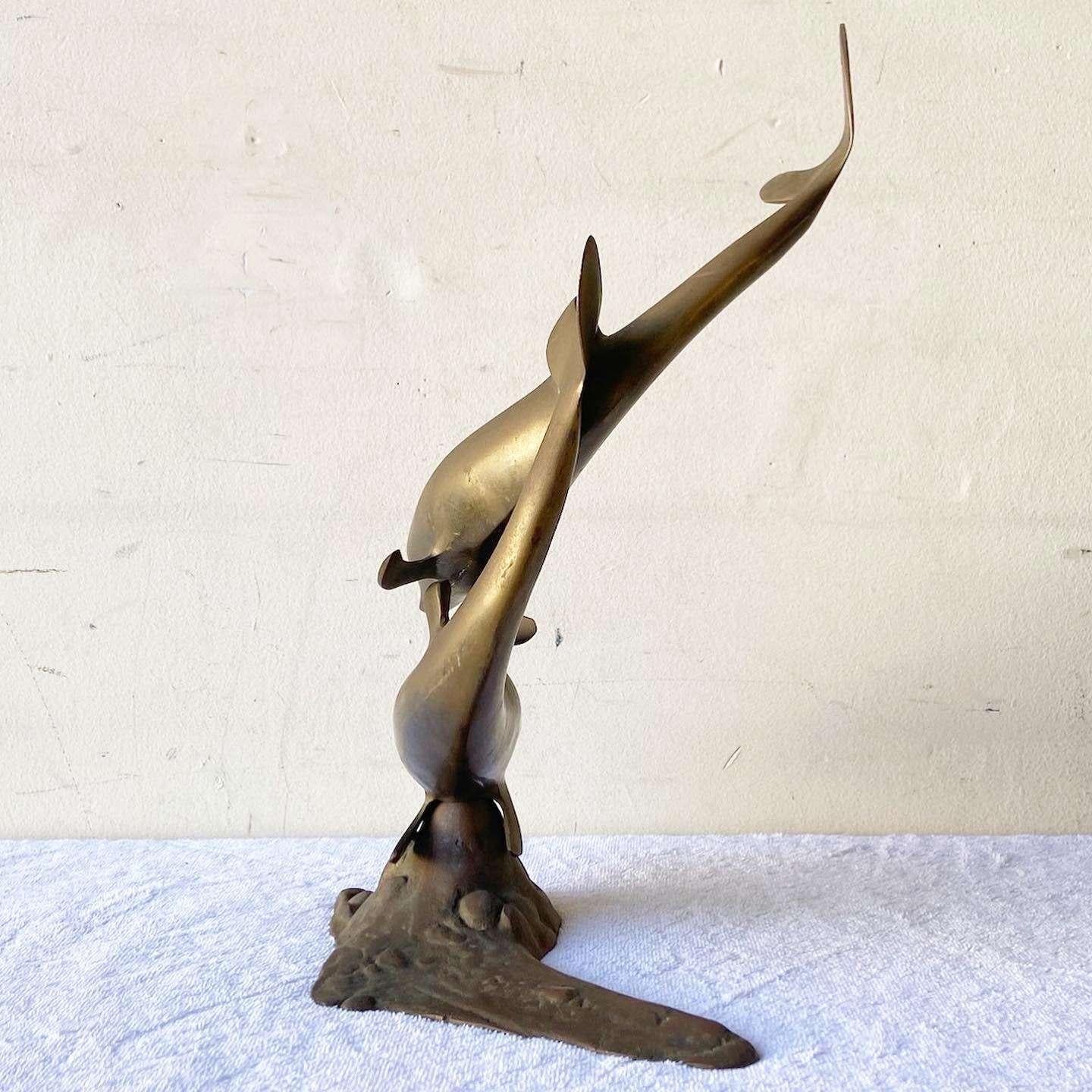 Incredible vintage mid century modern brass sculpture. Subject is pair of dolphins swimming.
