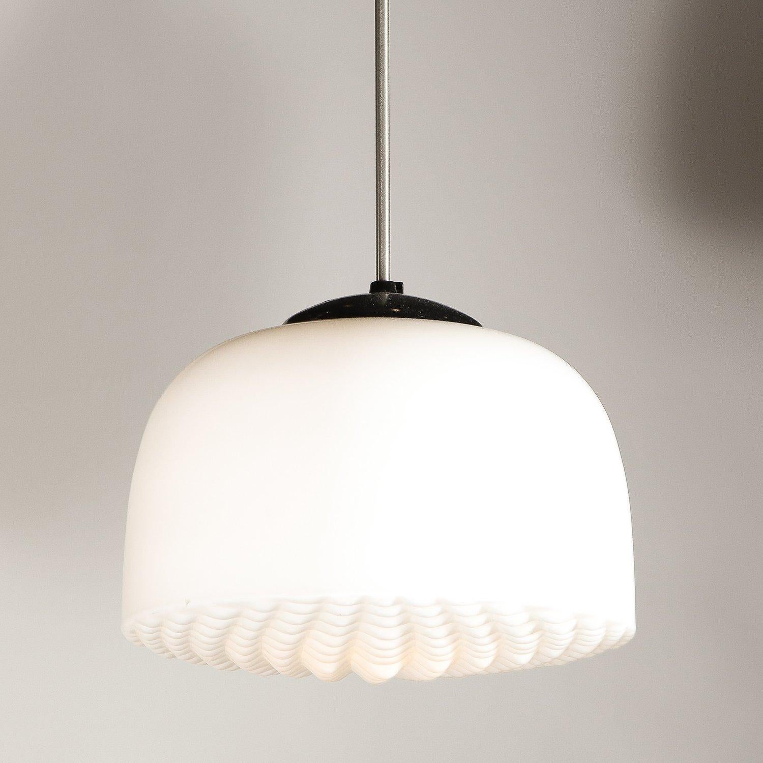 This refined Mid-Century Modern pendant was realized in the Czech Republic circa 1950. The feature graphic domed shade with a rectilinear 