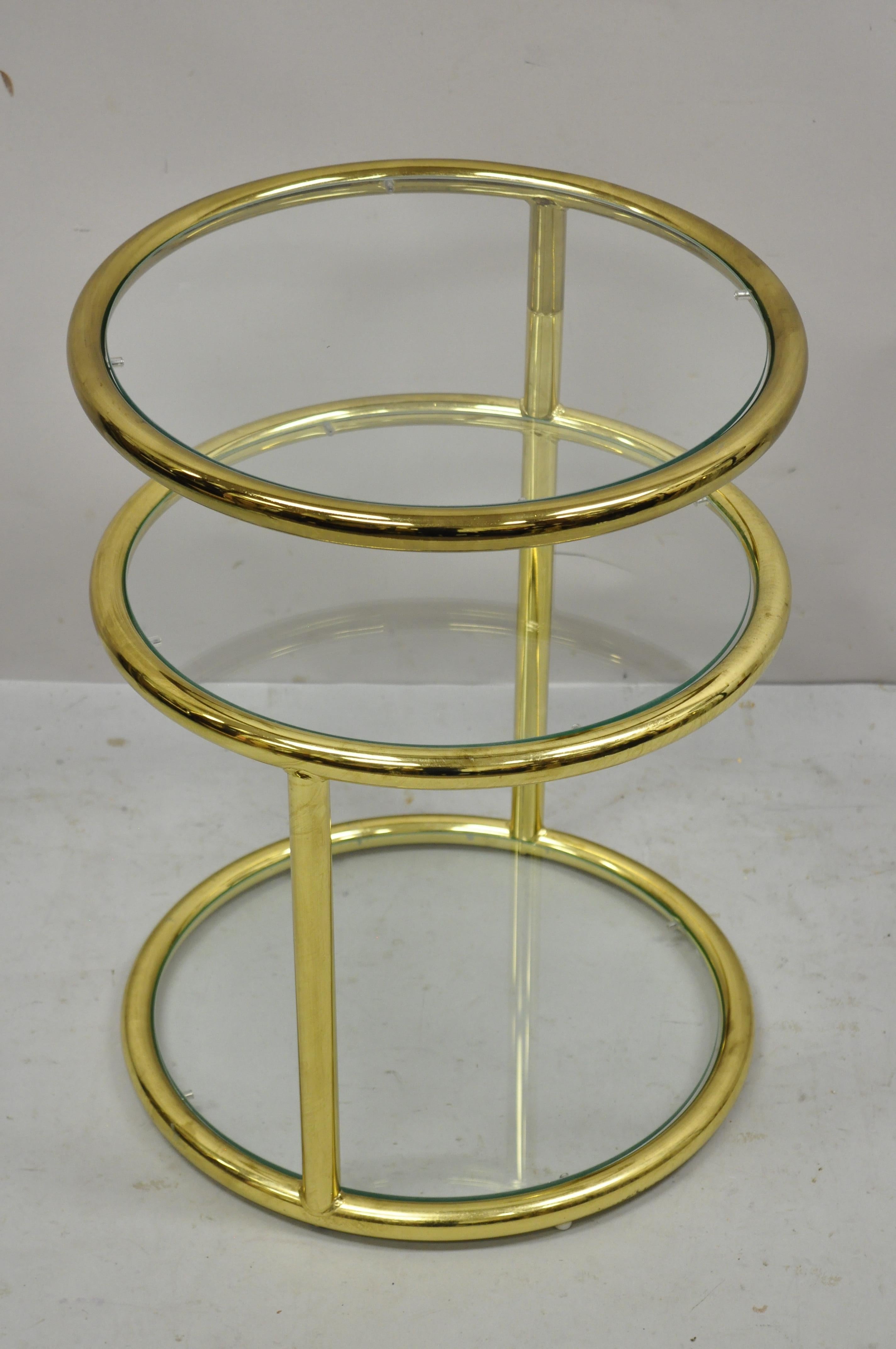 Mid-Century Modern brass frame 3 tier swivel Milo Baughman style round side table. Item features swivel top, 3 round glass tiers, brass plated frame, clean modernist lines, great style and form. Circa 1970s. Measurements: 22.5