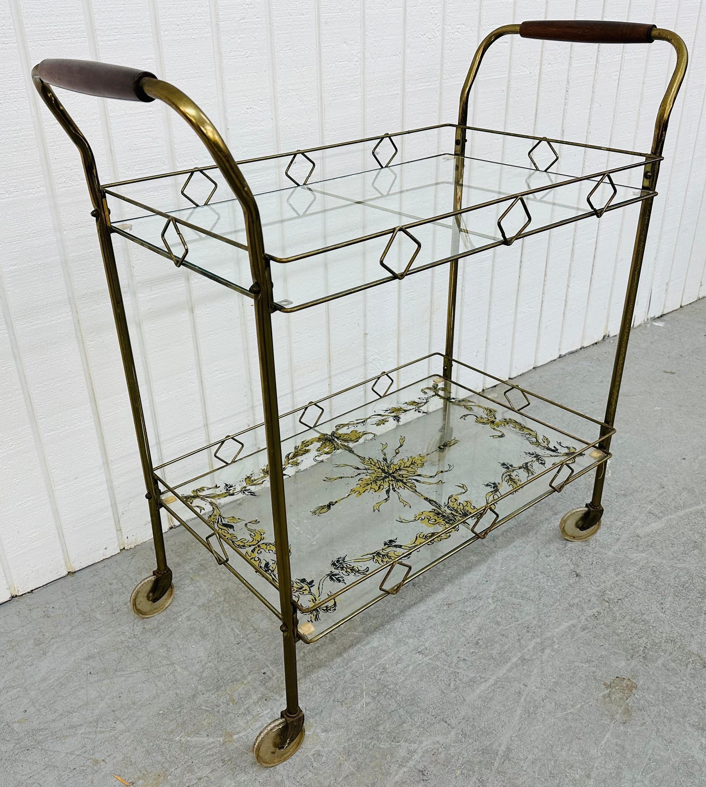 This listing is for a Mid-Century Modern Brass & Glass Bar Cart. Featuring a brass frame, clear glass top shelf, decorative glass bottom shelf, walnut handles, and original wheels. This is an exceptional combination of quality and design!