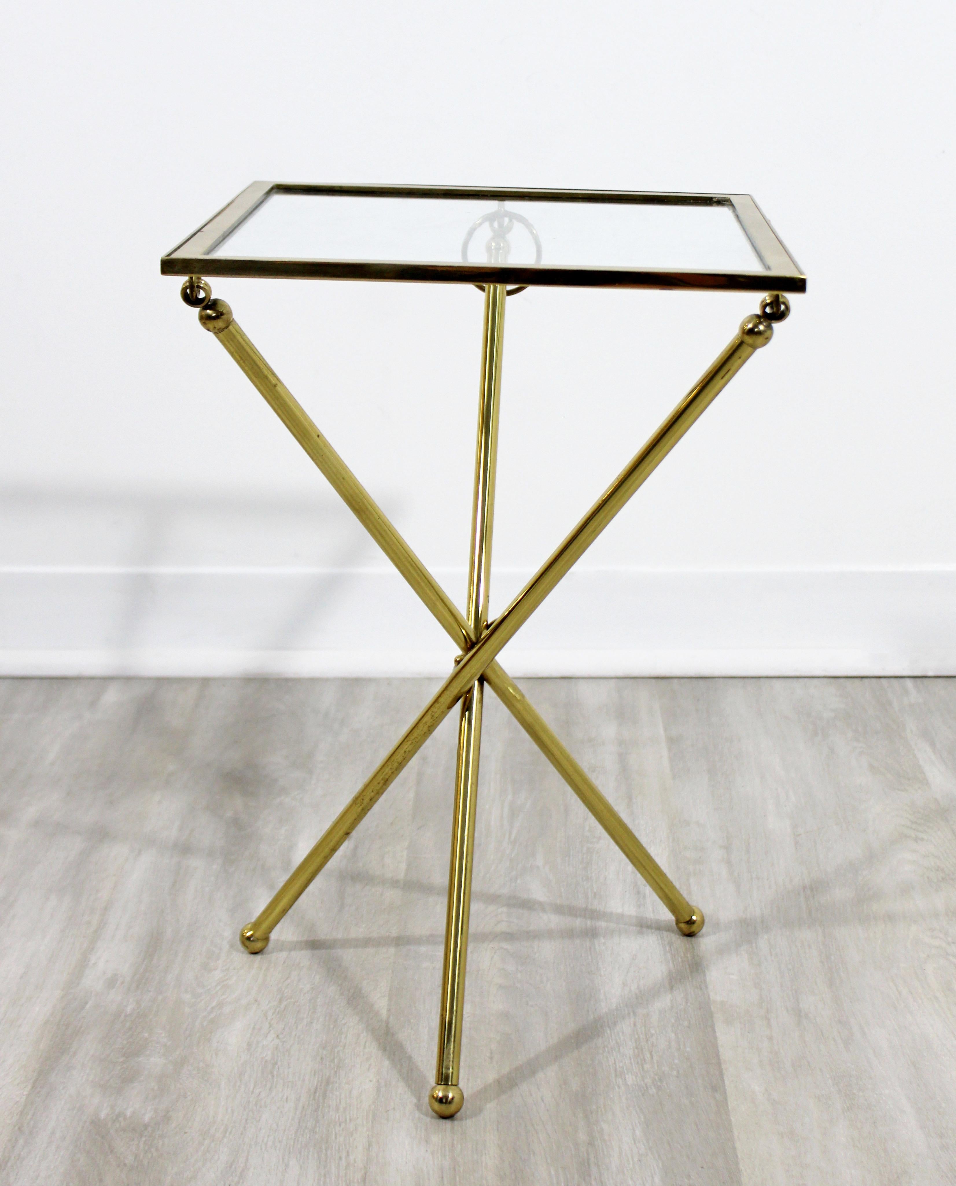 For your consideration is a gorgeous, small side or end table, made of brass and with glass top, with folding capabilities for storage, circa 1950s. In very good vintage condition. The dimensions are 12
