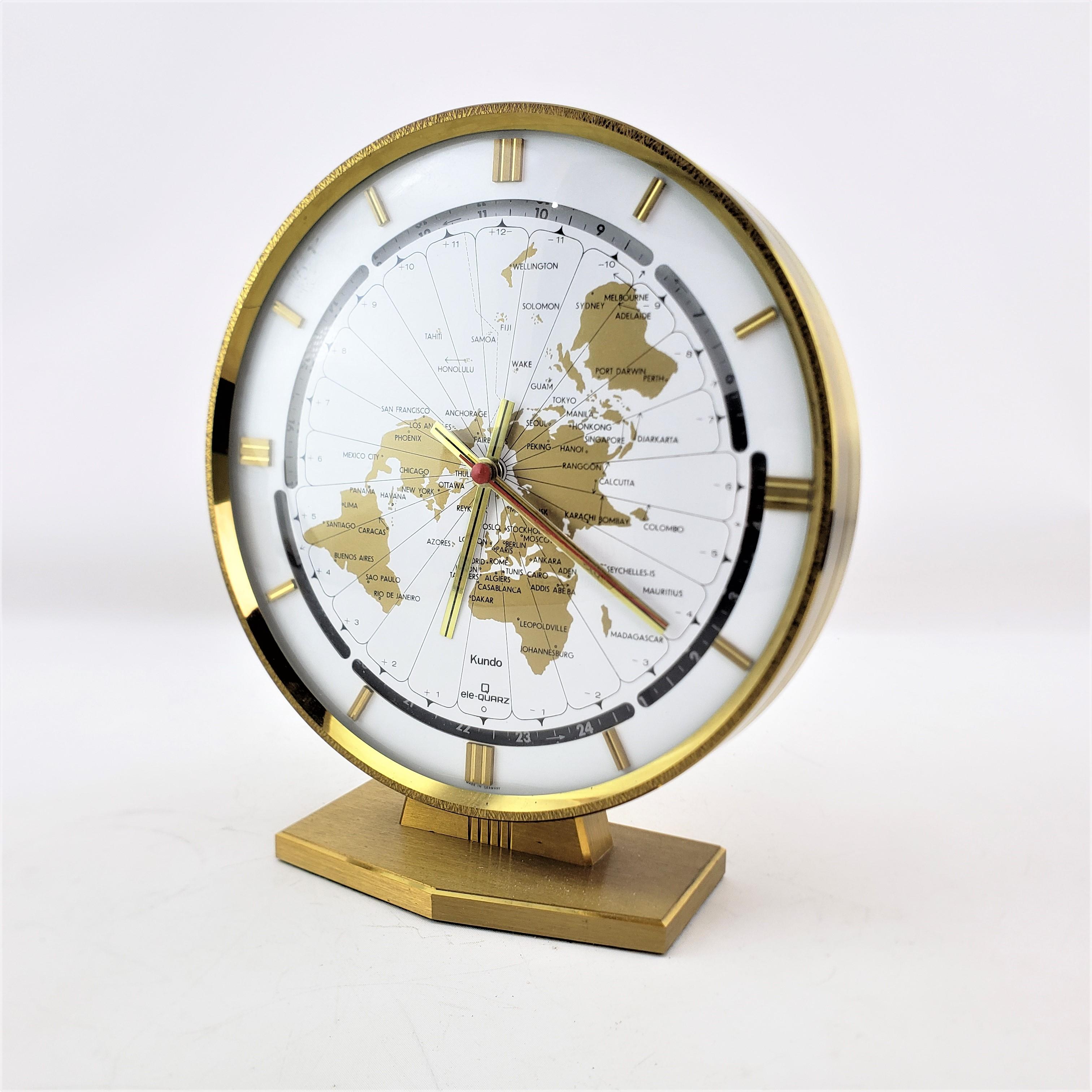 This clock was made by the well known Kundo clock company of Germany and dates to approximately 1970 and done in a Mid-Century Modern style. This World globe clock shows the various time zones on the face, with a black and light indicator band to