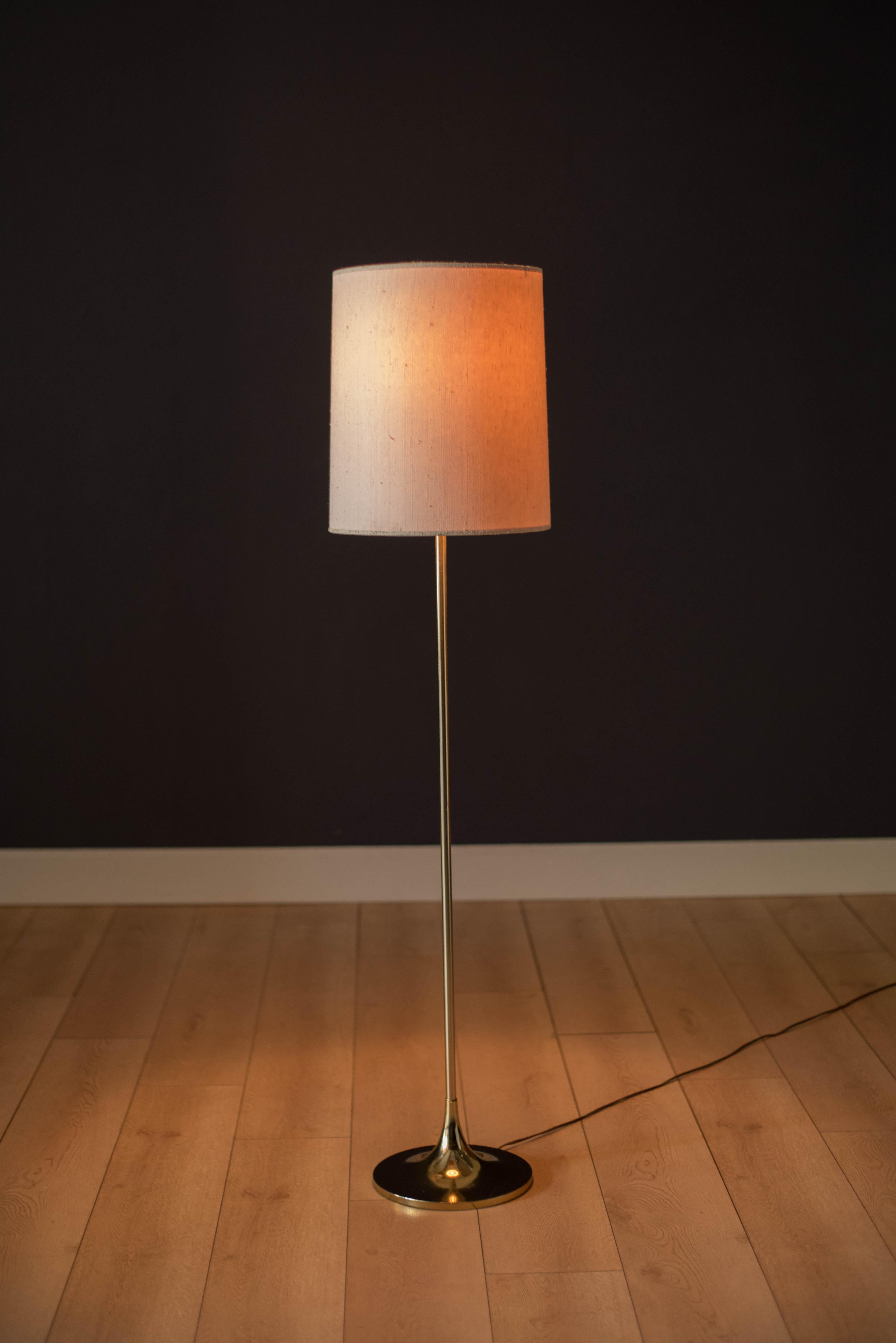 Mid-Century Modern Laurel floor lamp, circa 1960s. This sculptural piece features a weighted brass plated stem complete with Laurel lamp's signature finial. Includes a three-way switch mechanism. Drum shade is not included.