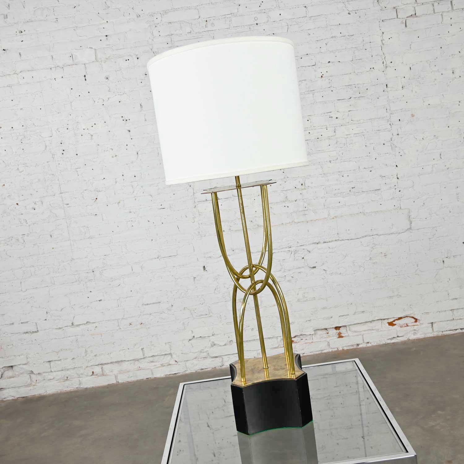 Beautiful brass looped tube table lamp with painted wood base, and newer style white drum shade. Lovely condition, keeping in mind that this is vintage and not new so will have signs of use and wear. We have left the natural patina on the brass body