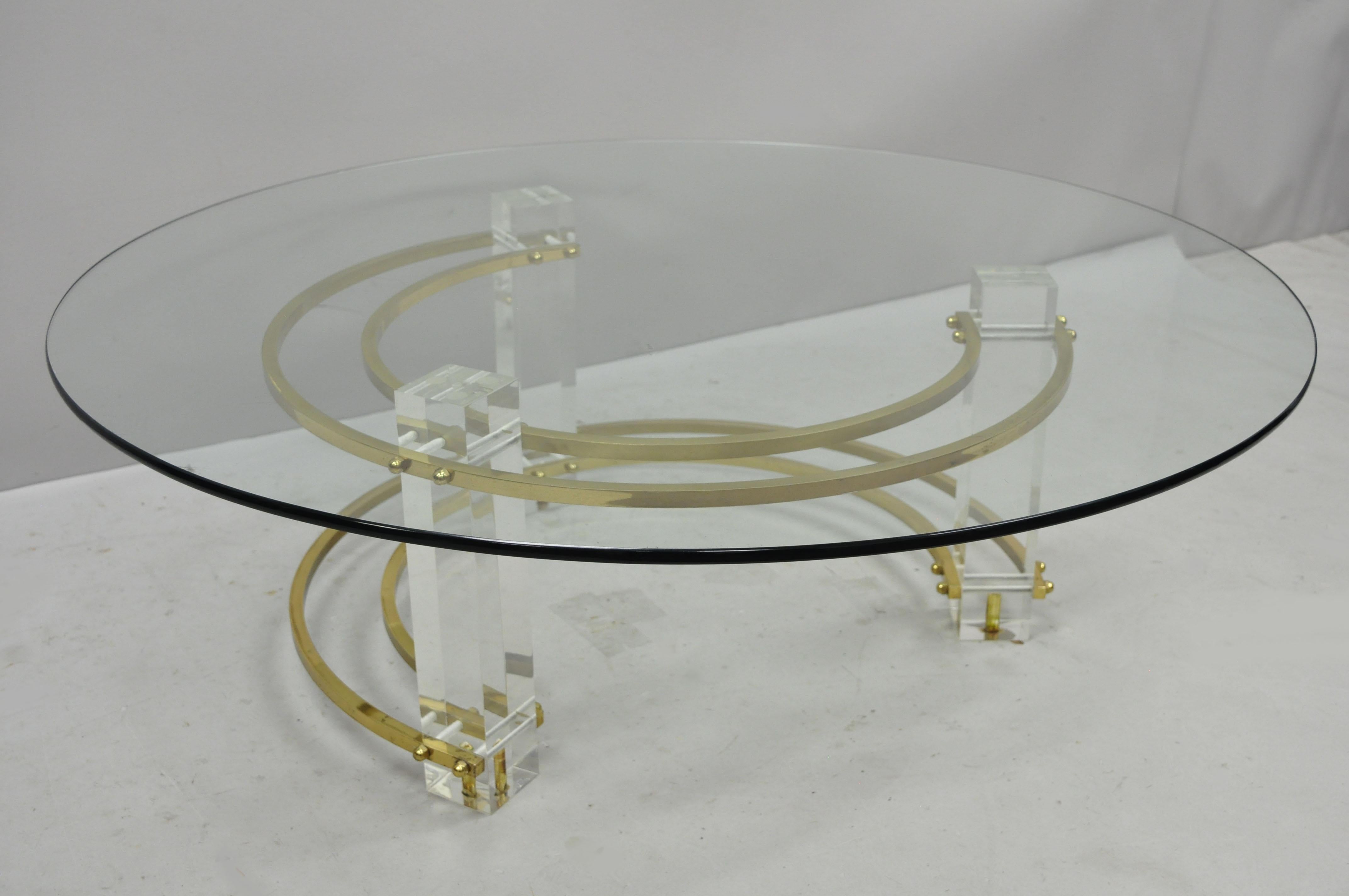 Mid-Century Modern brass Lucite round glass Charles Hollis Jones coffee table. Item features three Lucite column-form legs, brass supports, round glass top, sleek sculptural form, circa mid-20th century. Measurements: 13.5