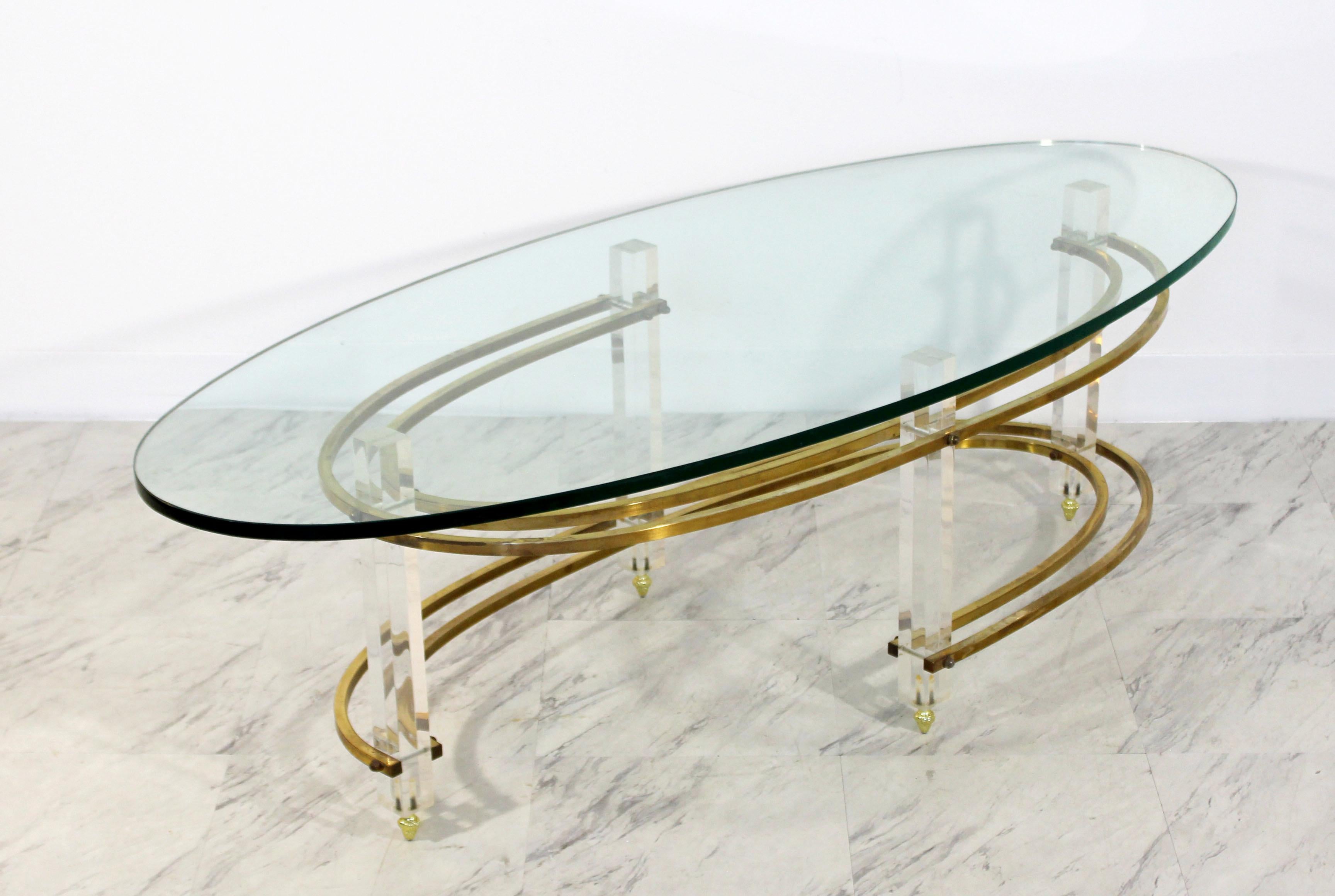 For your consideration is a fabulous, surfboard coffee table, with a brass and Lucite base and glass top, in the style of Charles Hollis Jones, circa the 1970s. In very good condition. The dimensions are 56