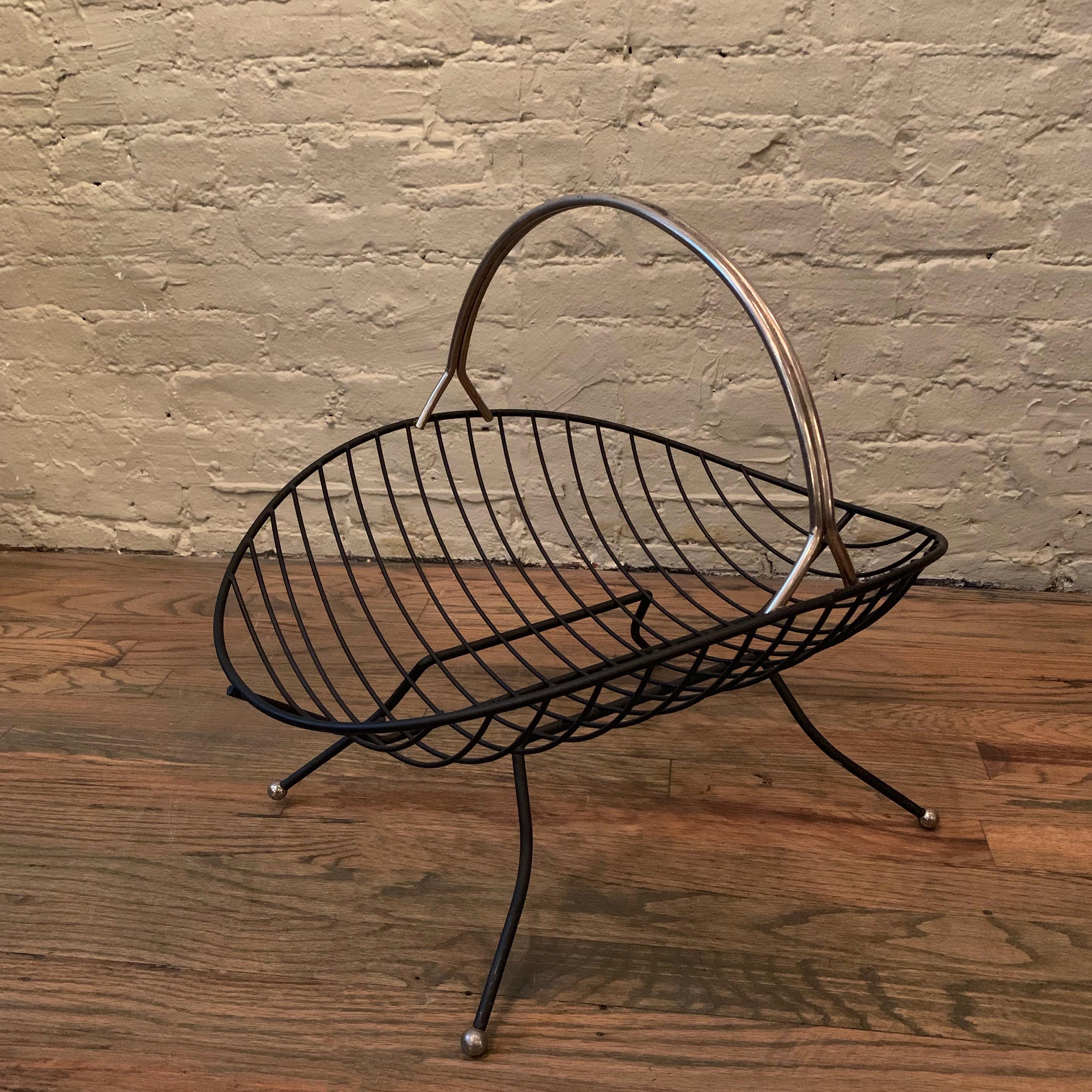 Mid-Century Modern, low scooped, brass rack with handle can be used as a magazine or fireplace log holder.