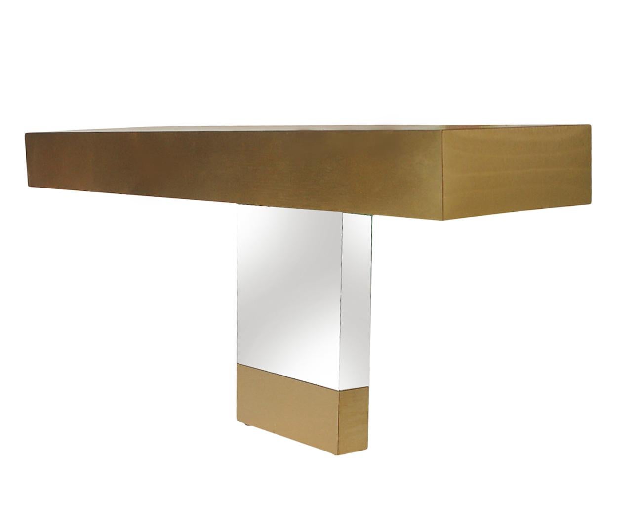 A chic and glamorous floating console table in the style of Paul Evans, circa 1970s. This console is wall-mounted and consists of brushed brass and mirror finish.