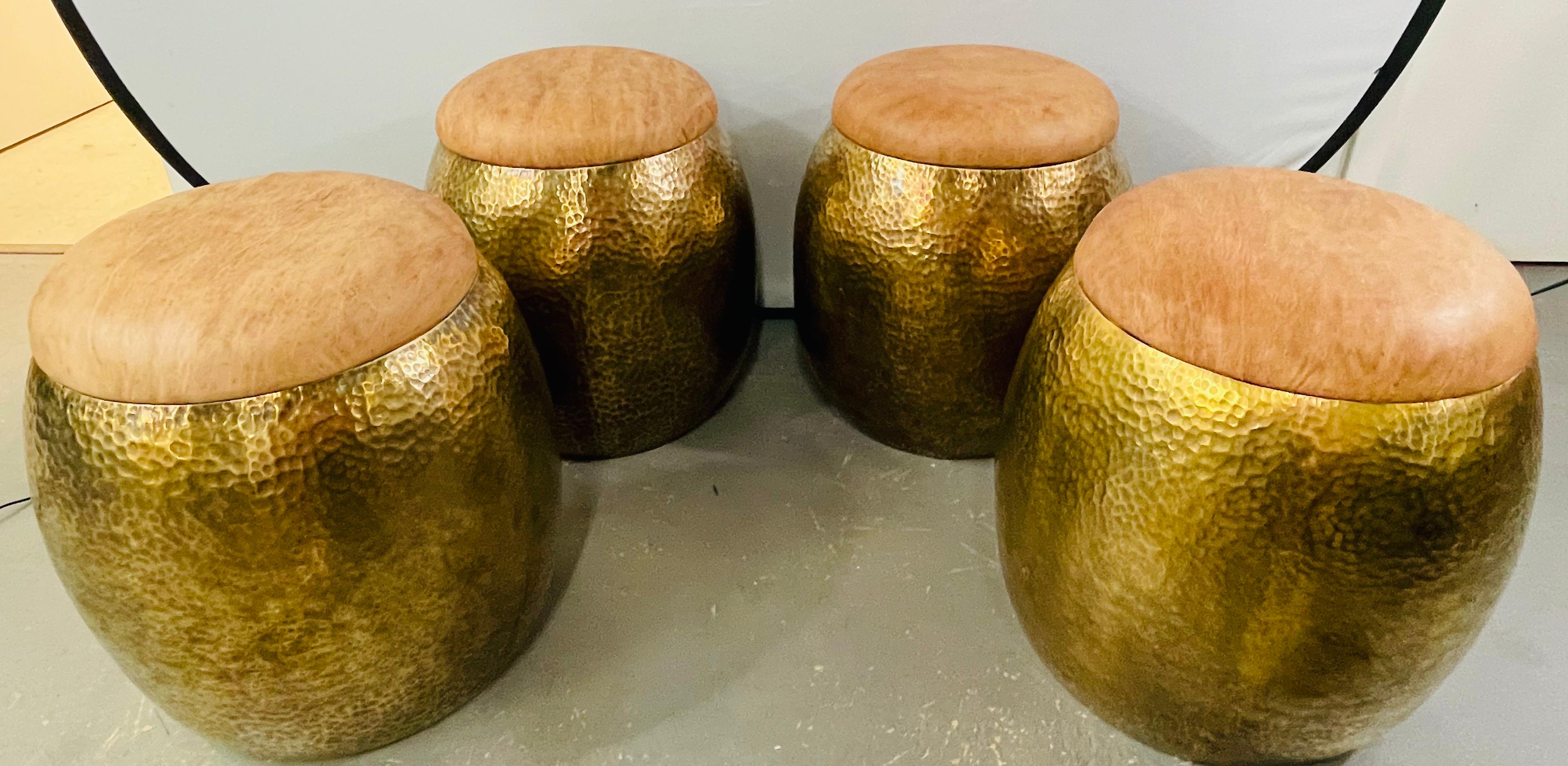 A very chic set of four Mid-Century Modern ottomans or stools handmade using the finest leather in a classy and fashionable natural beige or light brown tone and quality gold brass. The handcrafted stool features a hammered style with an antique