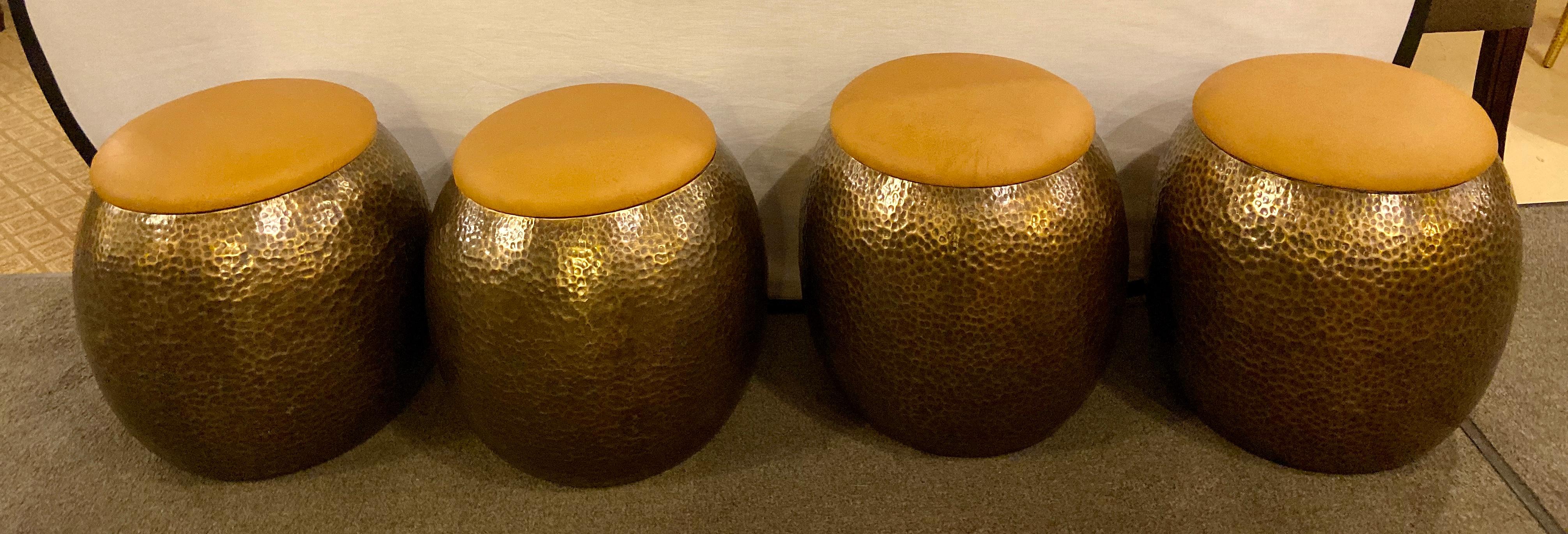 A very chic set of four Modern ottomans or stools handmade using the finest leather in a classy beige or light brown tone and quality gold brass. The handcrafted stool features a hammered style with an antique finish. The stools are steady and can