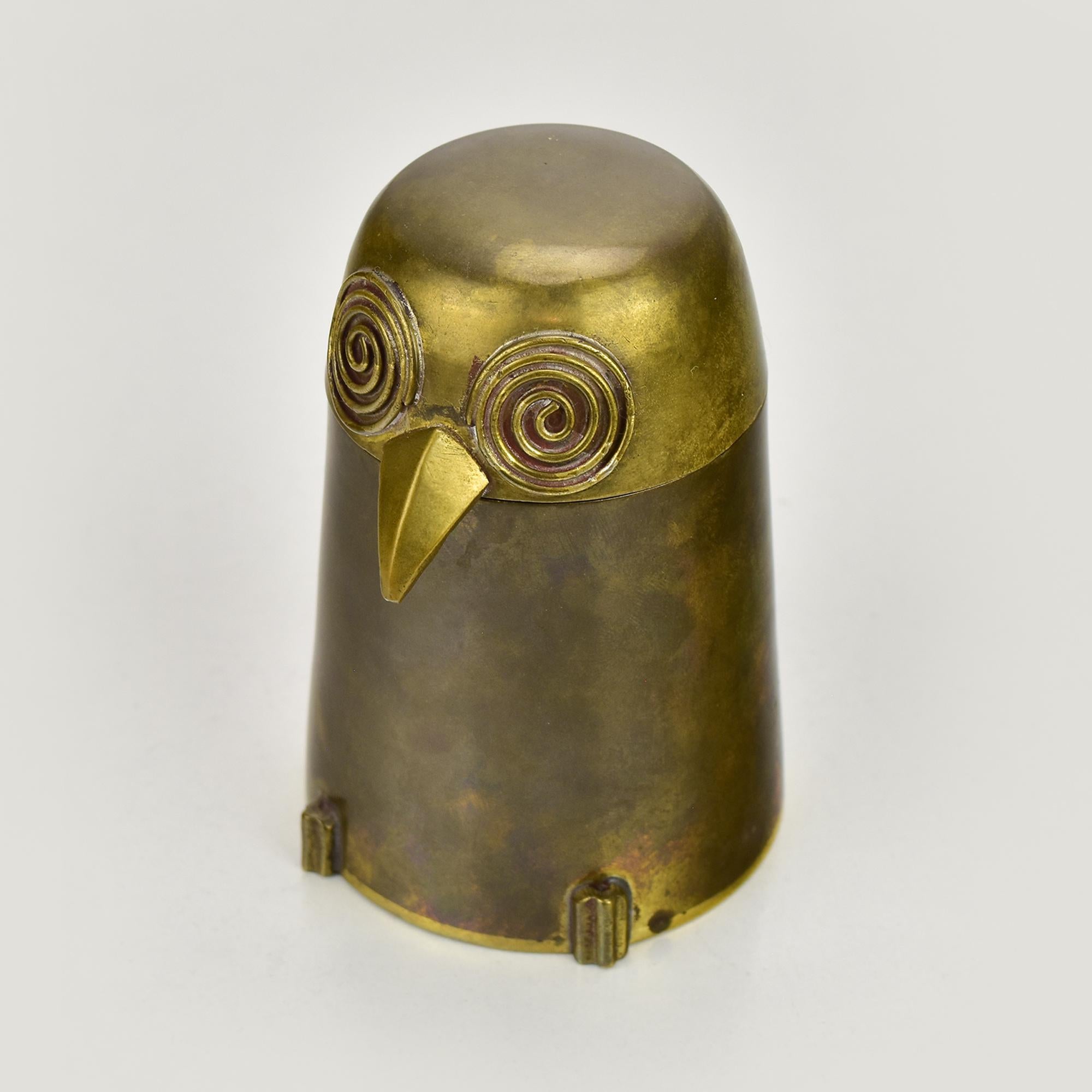 This charming Mid-Century Modern brass owl box is a delightful decorative object that combines whimsy with clean, sculptural design. Crafted in solid brass with a warm, naturally aged patina, the piece features a stylised conical body and a
