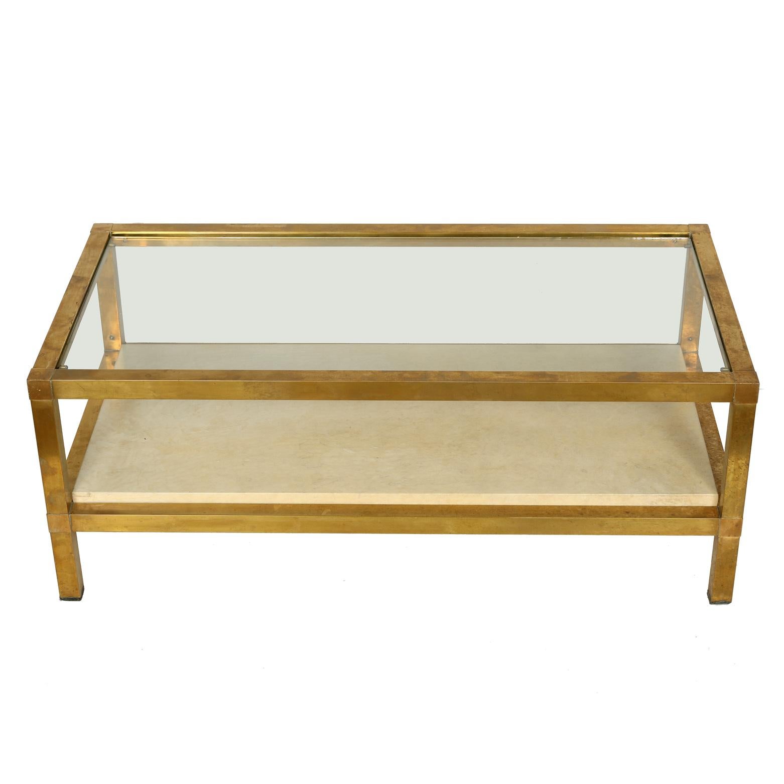 Mid-Century Modern rectangular brass coffee table with glass top and parchment shelf.