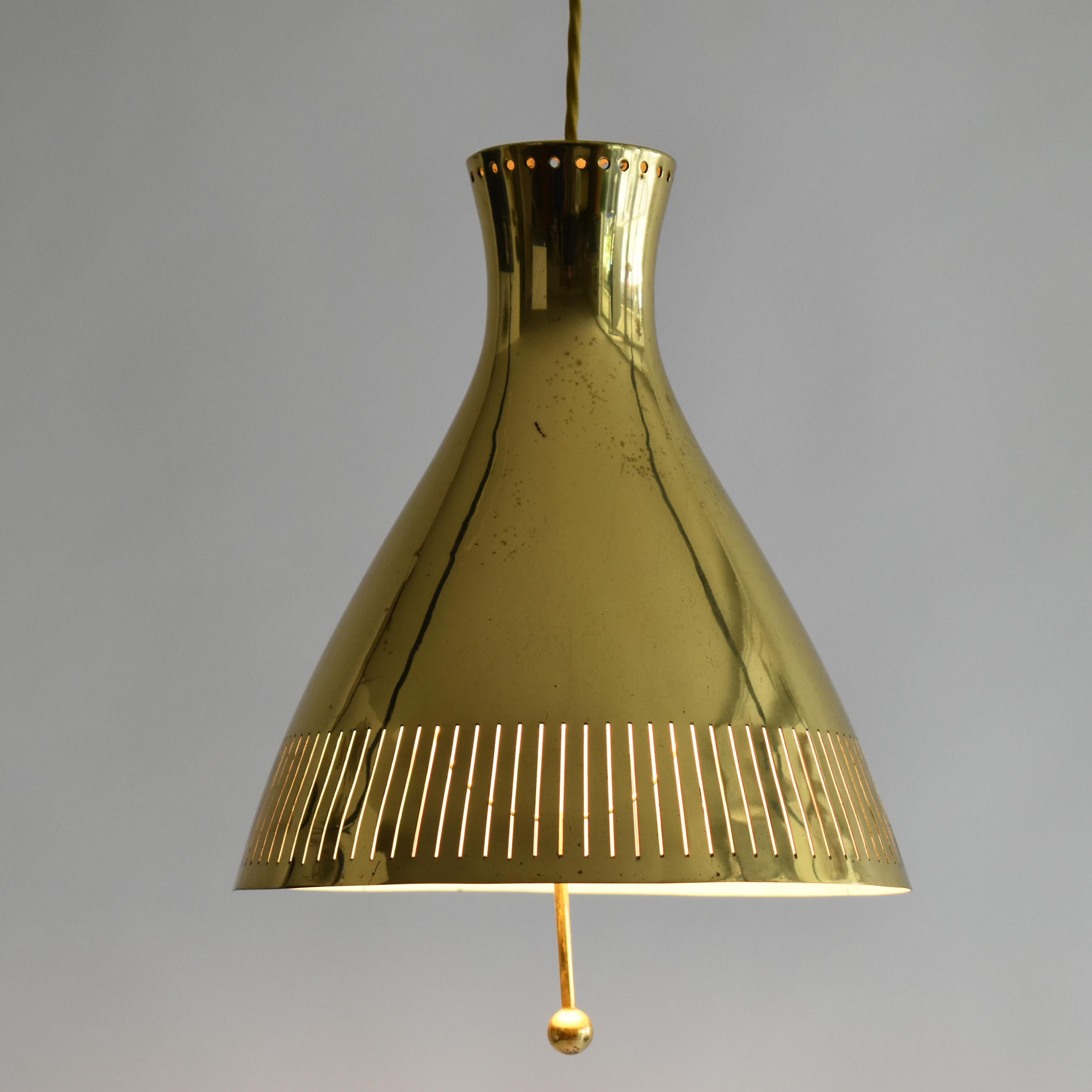 Extremely rare and elegant Mid-Century Modern brass pendant lamp or hanging light. 
Designed and manufactured by the high quality producer Vereinigte Werkstätten, in Germany.
Executed in perforated brass sheet, with a handle, it gives a nice and