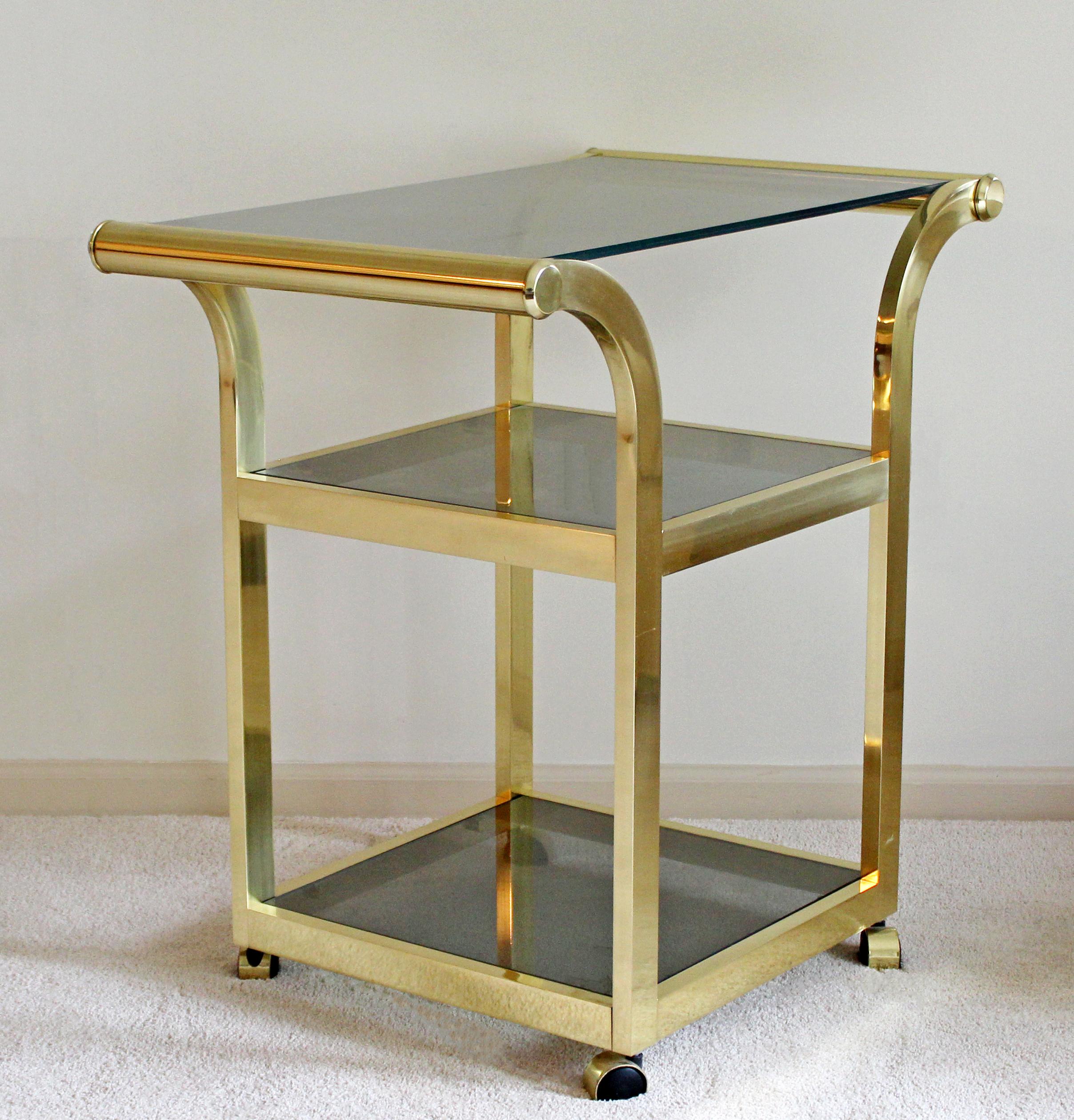 For your consideration is an incredibly sexy trolley cart, on wheels, made of brass and with three smoked glass shelves, circa the 1970s. Attributed to Milo Baughman. In very good vintage condition. The dimensions are 30