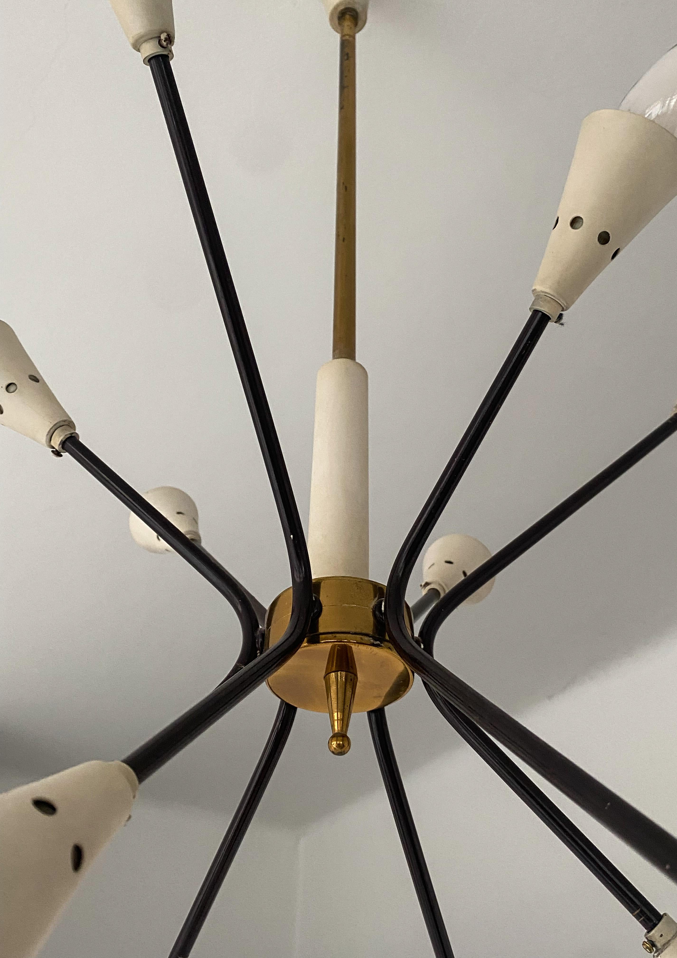 Mid-Century Modern Brass Sputnik chandelier black and beige in the style of Stilnovo, Italy 1950s

This Sputnik Chandelier in the style of the famous Italian brand Stilnovo features 12 golden brass elements and black curved rods with eleven conical