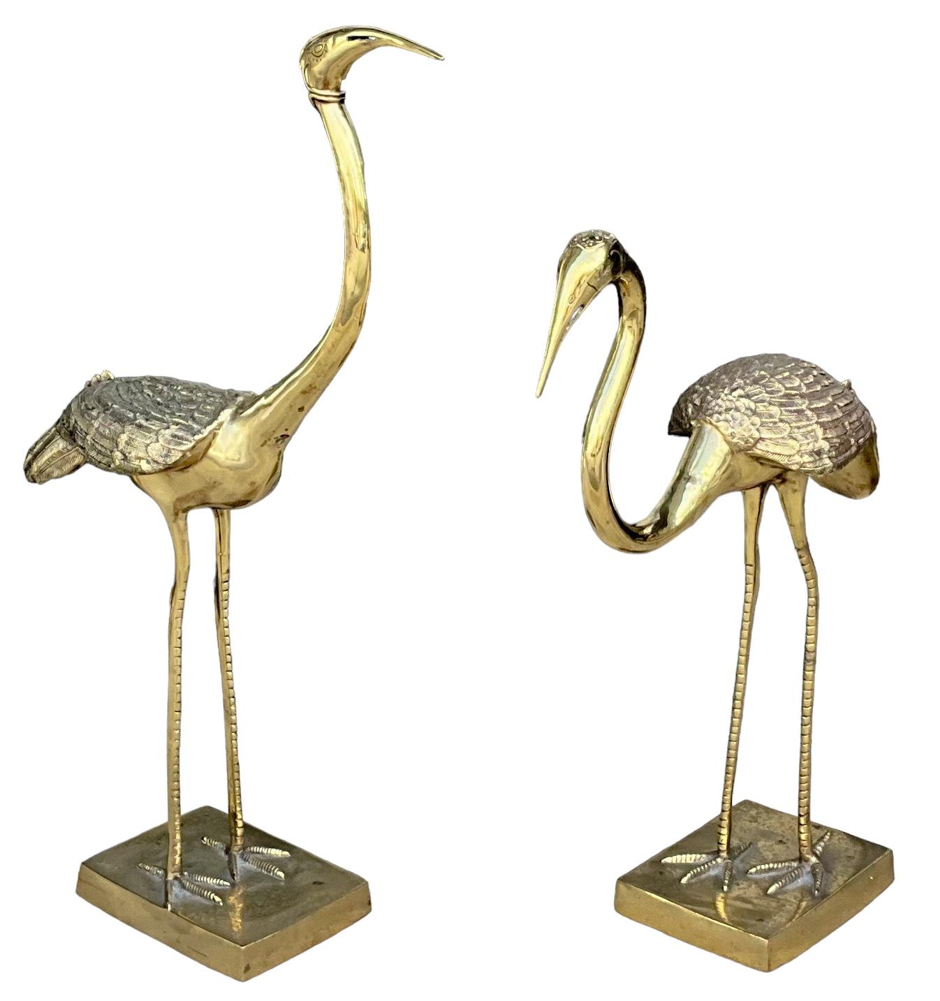 This is a pair of mid-century modern  standing brass cranes or herons in the style of Jack Housman. They are purported to be Italian. They faces have an almost art nouveau appearance to them. They are unmarked and in very good condition. The smaller
