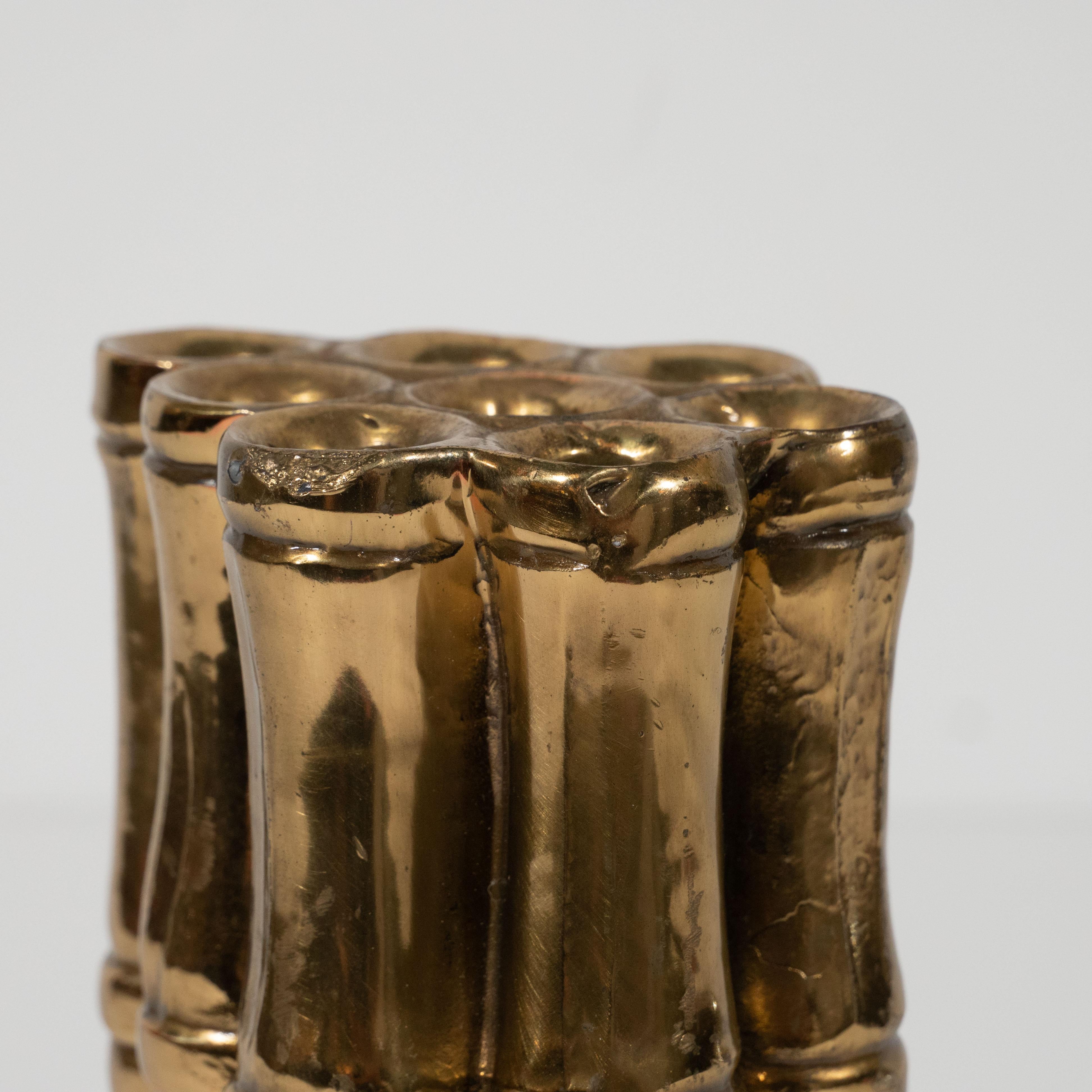 This refined flower holder was realized in the United States, circa 1970. It features eight conjoined cylindrical forms of stylized cane bamboo segments with three sets of incised banding (top, bottom, and center) details representing their joints.