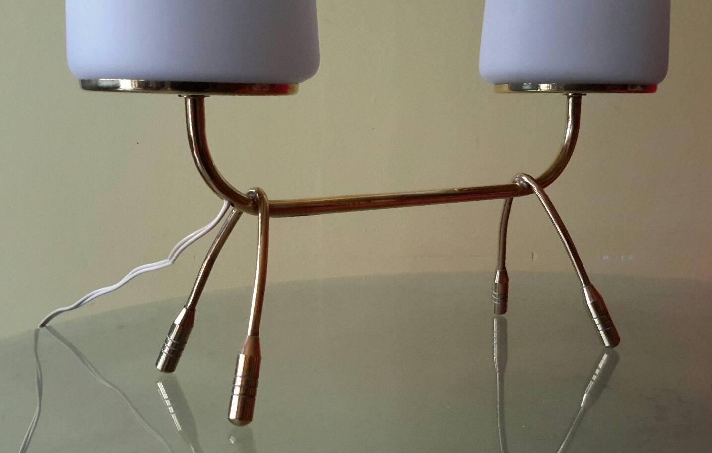 Magnifique lampe de table à structure minimaliste en laiton avec un grand diffuseur en opaline, France, années 1950
La lampe est en excellent état avec deux grands diffuseurs en opaline blanc mat.
Le câblage est conforme aux normes