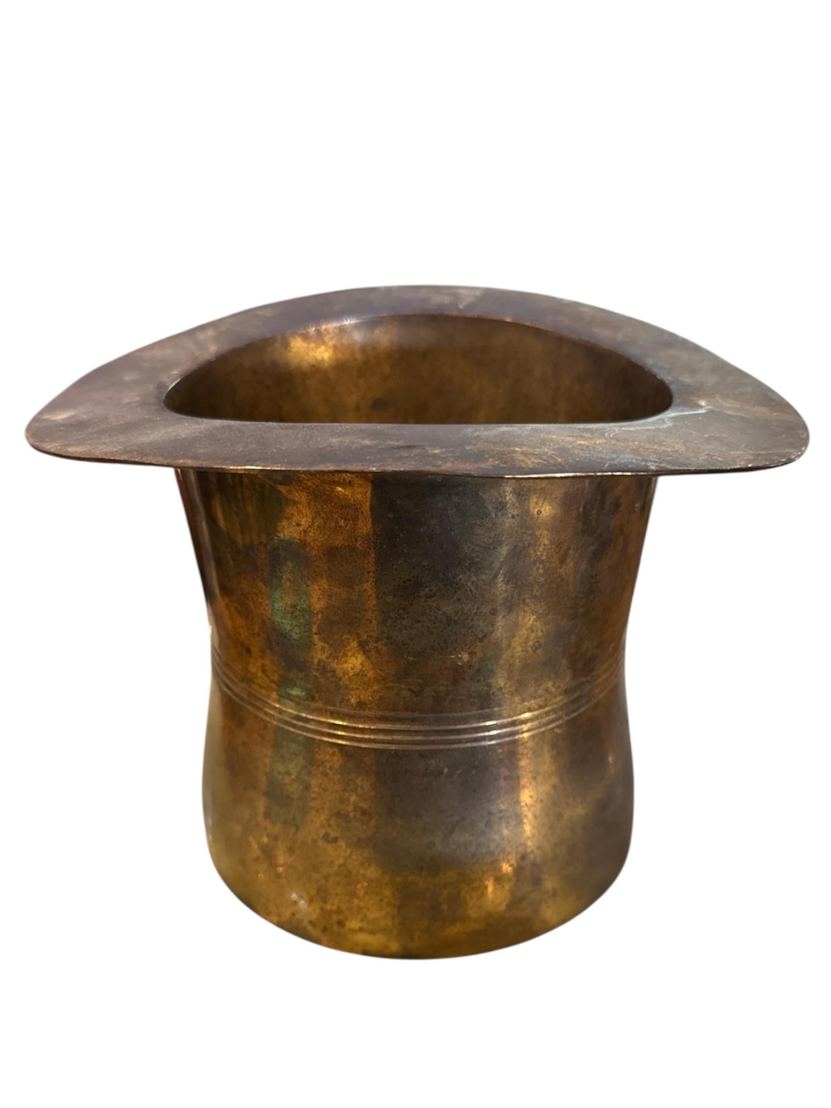 Infuse your décor with a dash of whimsical elegance with this Mid-Century Modern Brass Top Hat. Expertly crafted from solid brass, this sculptural piece channels the playful spirit and sleek aesthetic of mid-century design.