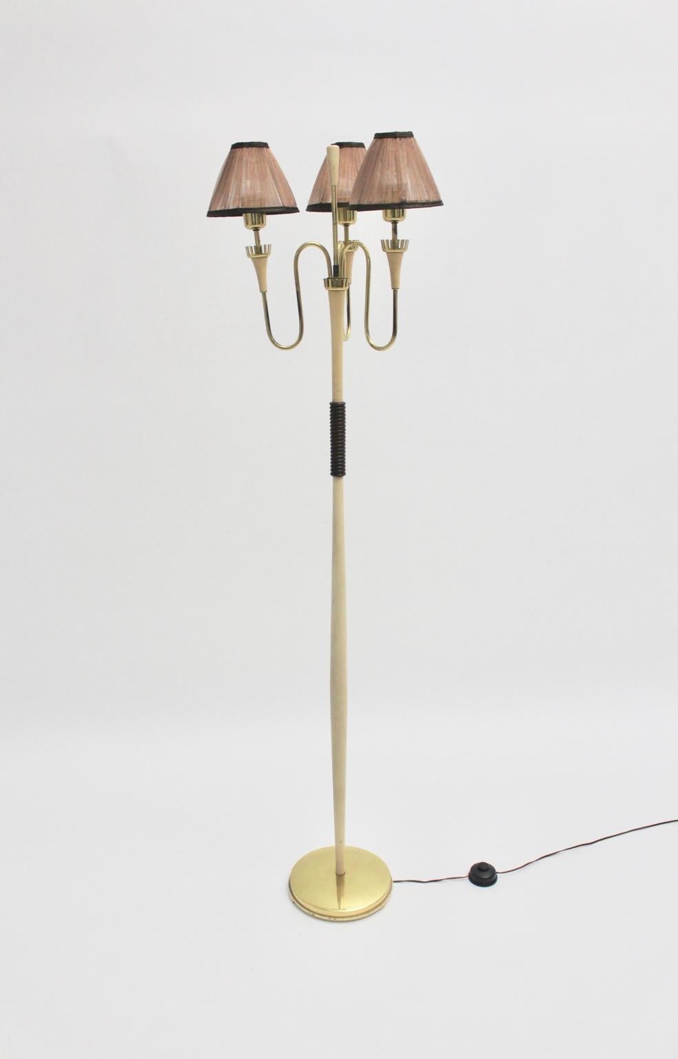Mid century modern brass vintage floor lamp from white lacquered wood and brass style Gio Ponti 
and Pietro Chiesa 1940s in Italy. 
An elegant and gorgeous floor lamp in the style of Gio Ponti and Pietro Chiesa shows three brassed slightly curved