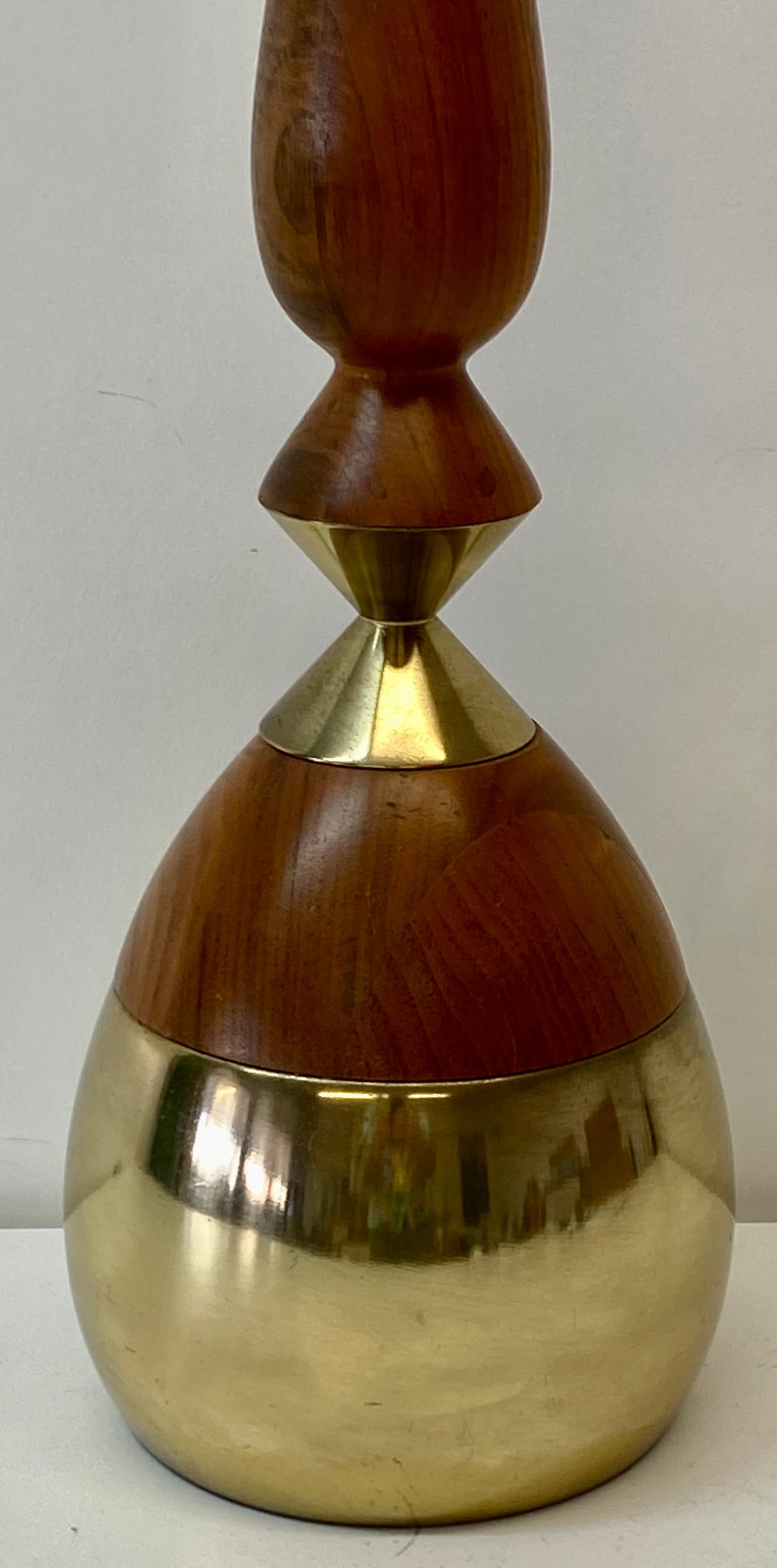 Mid-Century Modern brass and walnut table lamp, circa 1960

Bulbous brass base with a walnut neck

Very sleek and elegant

Measures: 6