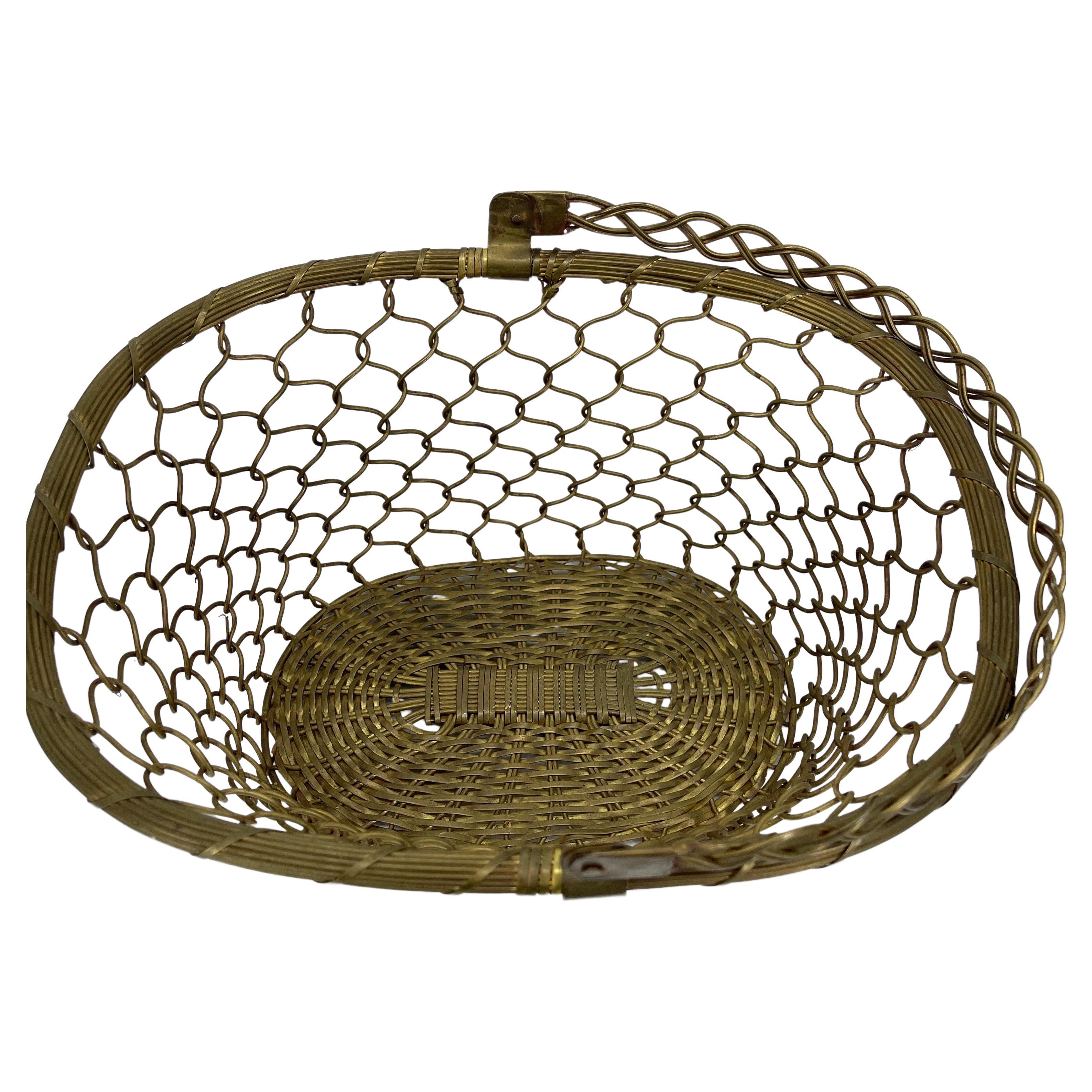 Mid-Century Modern brass wire basket, circa 1970's. This nifty basket is perfect on the table holding bread or as an egg basket in the kitchen. The wire is sturdy and in very good condition, as is the base. With it's large braided handle, the basket