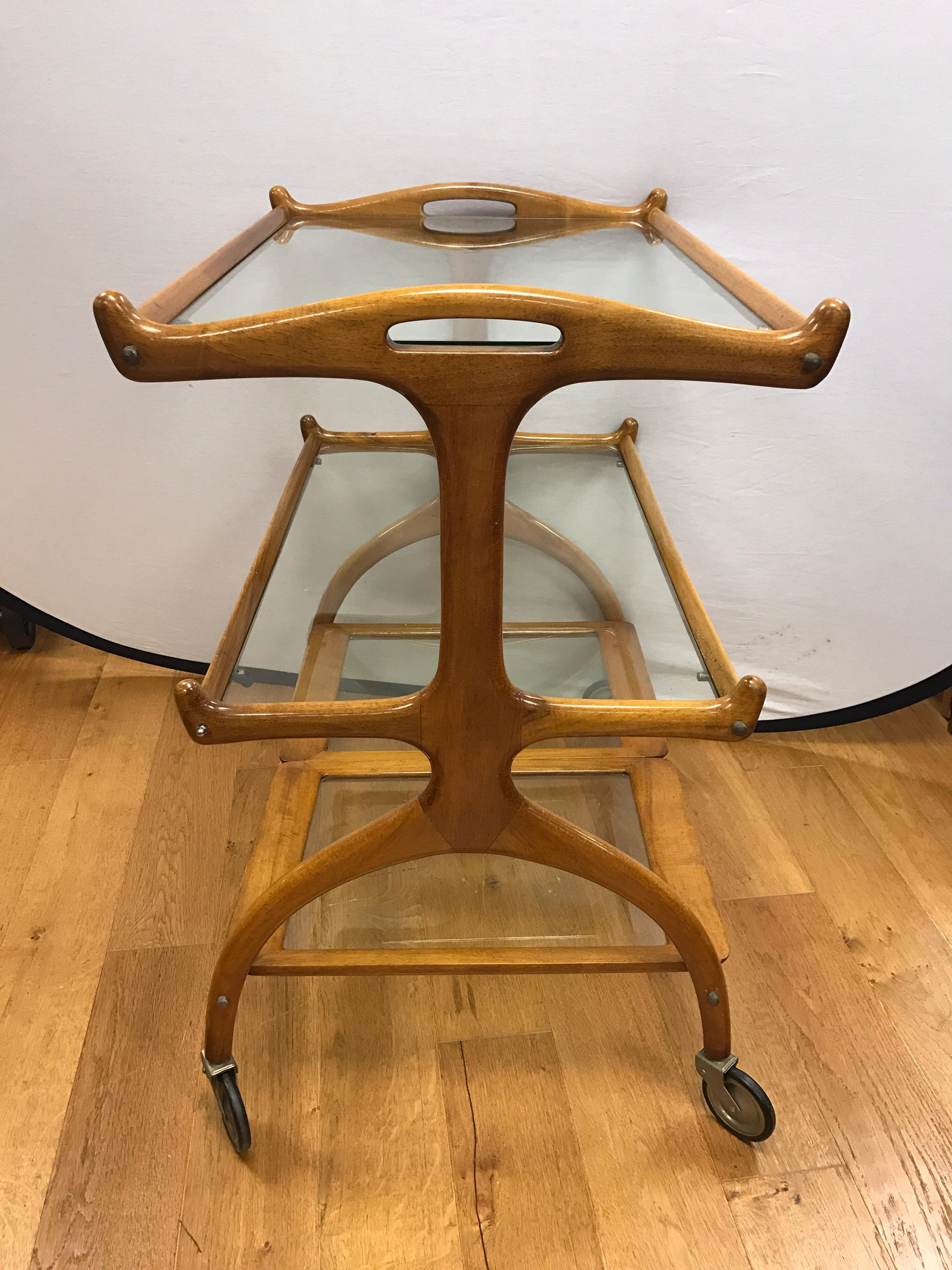 Rare three-tiered rolling bar cart from Brazil, circa early 1960s, made of Jacaranda wood. Bottom tier has two removable glass trays.