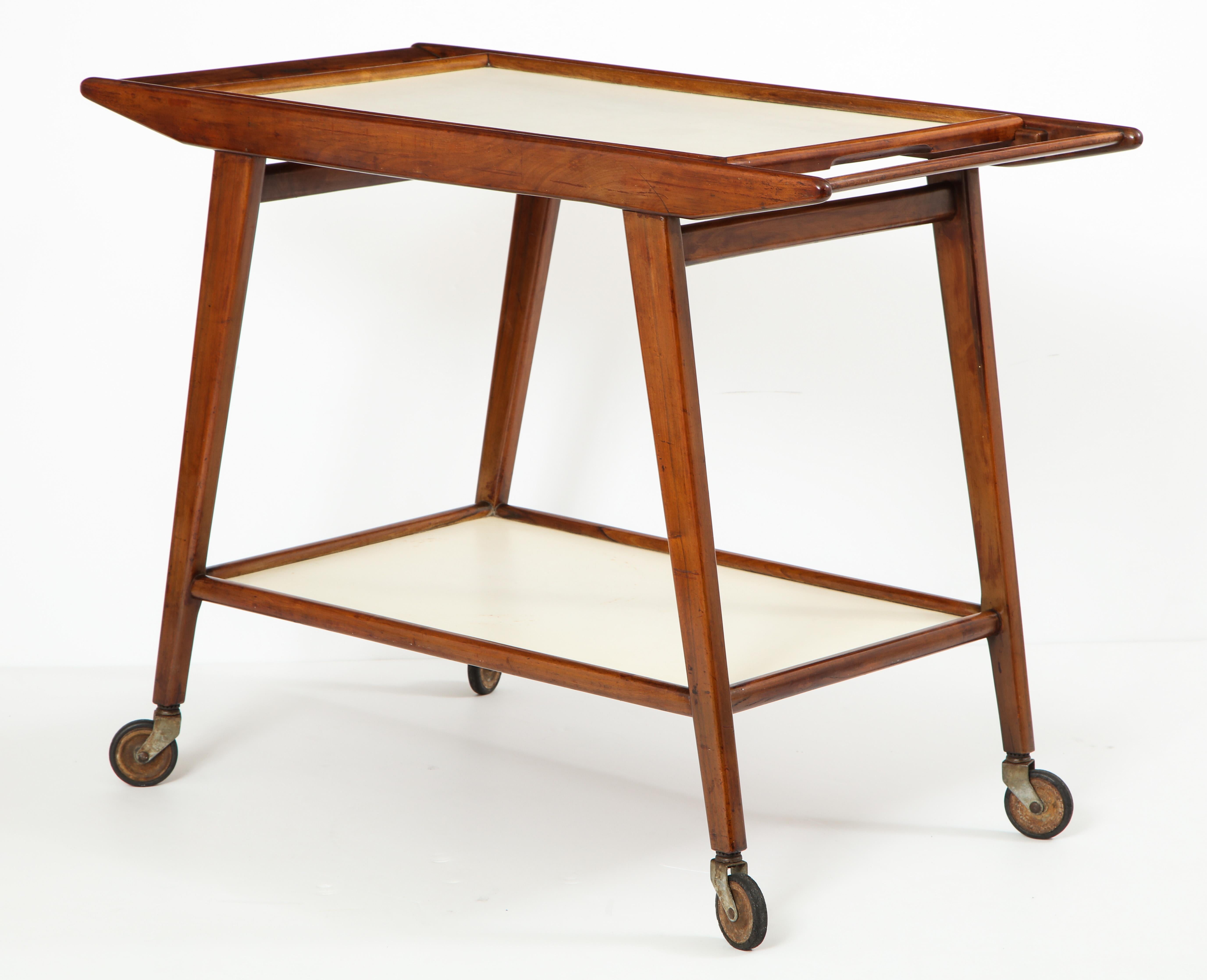 Mid-Century Modern Brazilian tea cart in solid hardwood with removable tray in white formica by OCA Manufacture.

This elegant wheeled tea-cart or bar-cart was produced in the 1950s by OCA Brazil Manufacture. It features two trays in white formica -