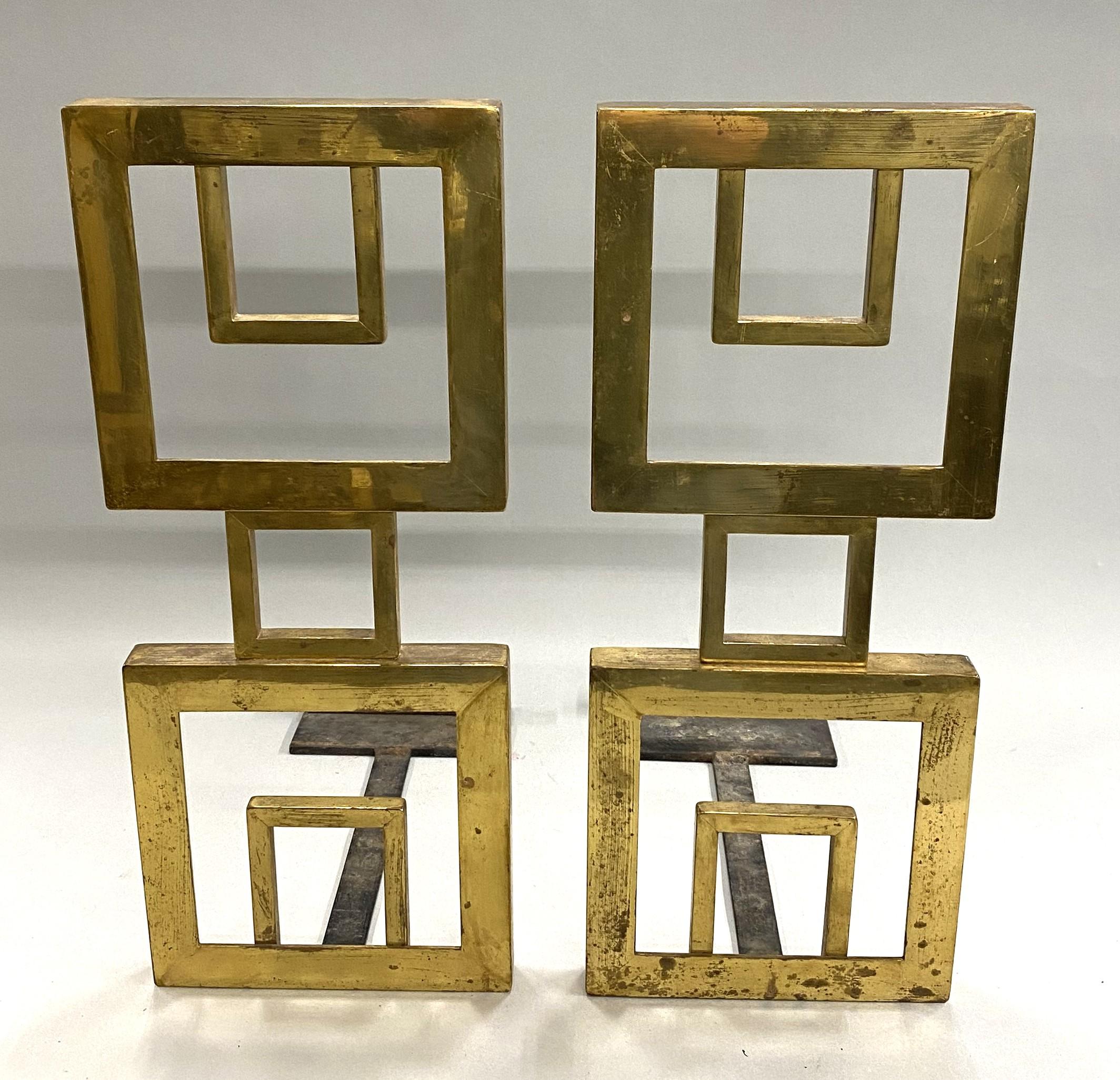 A fine pair of unsigned Mid Century Modern bronze geometric andirons with squares within squares, in brass finish with black iron dogs in very good condition, with some minor surface scratches, light rusting to dogs,  finish losses, imperfections,