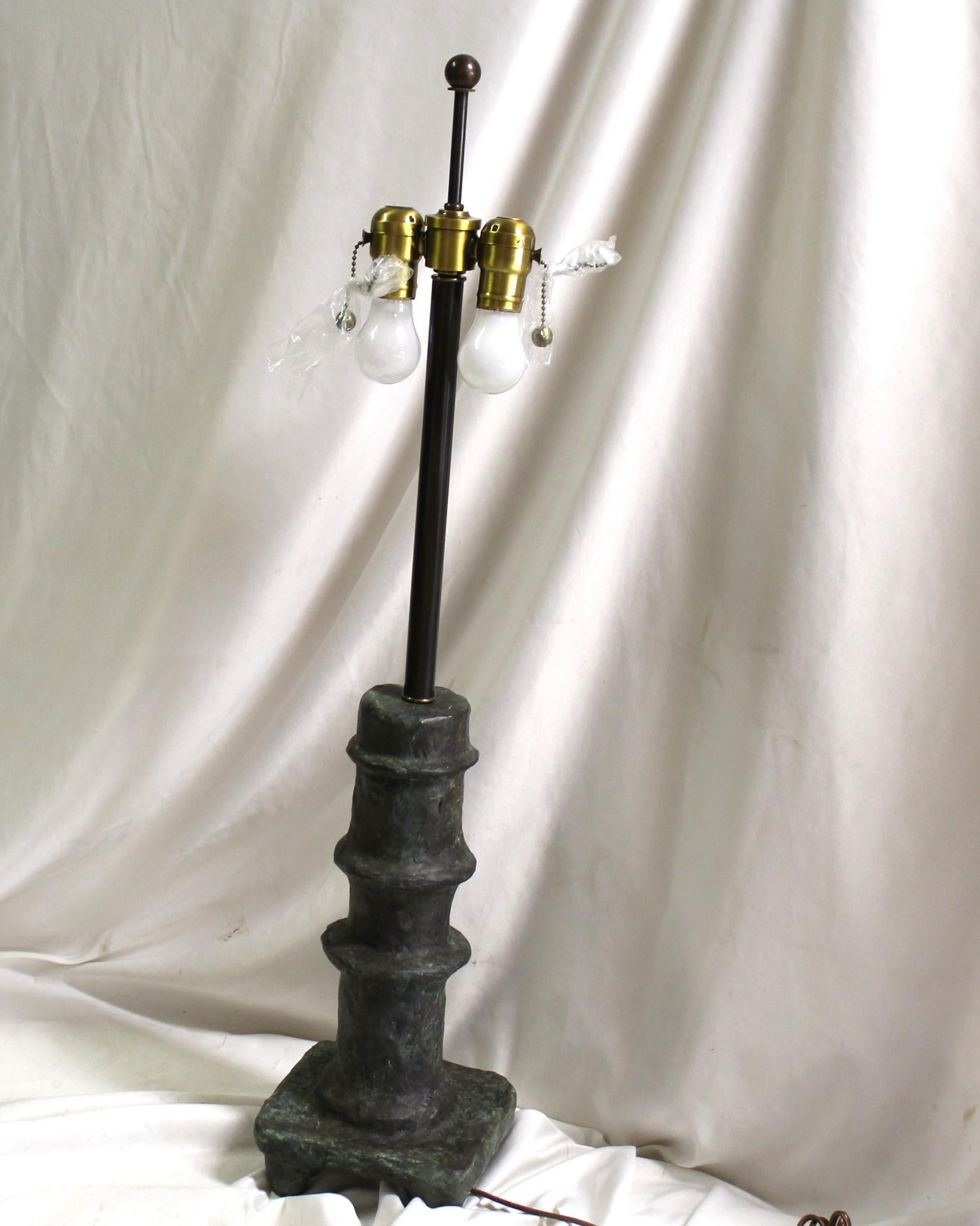 Una lampada dal design popolare realizzata in bronzo a cera persa con una patina marrone/verde. Con l'aspetto e la struttura tipici di Giacometti. Ha una doppia presa Delux con catene a strappo in solido ottone antico. Bronzo pesante con una base