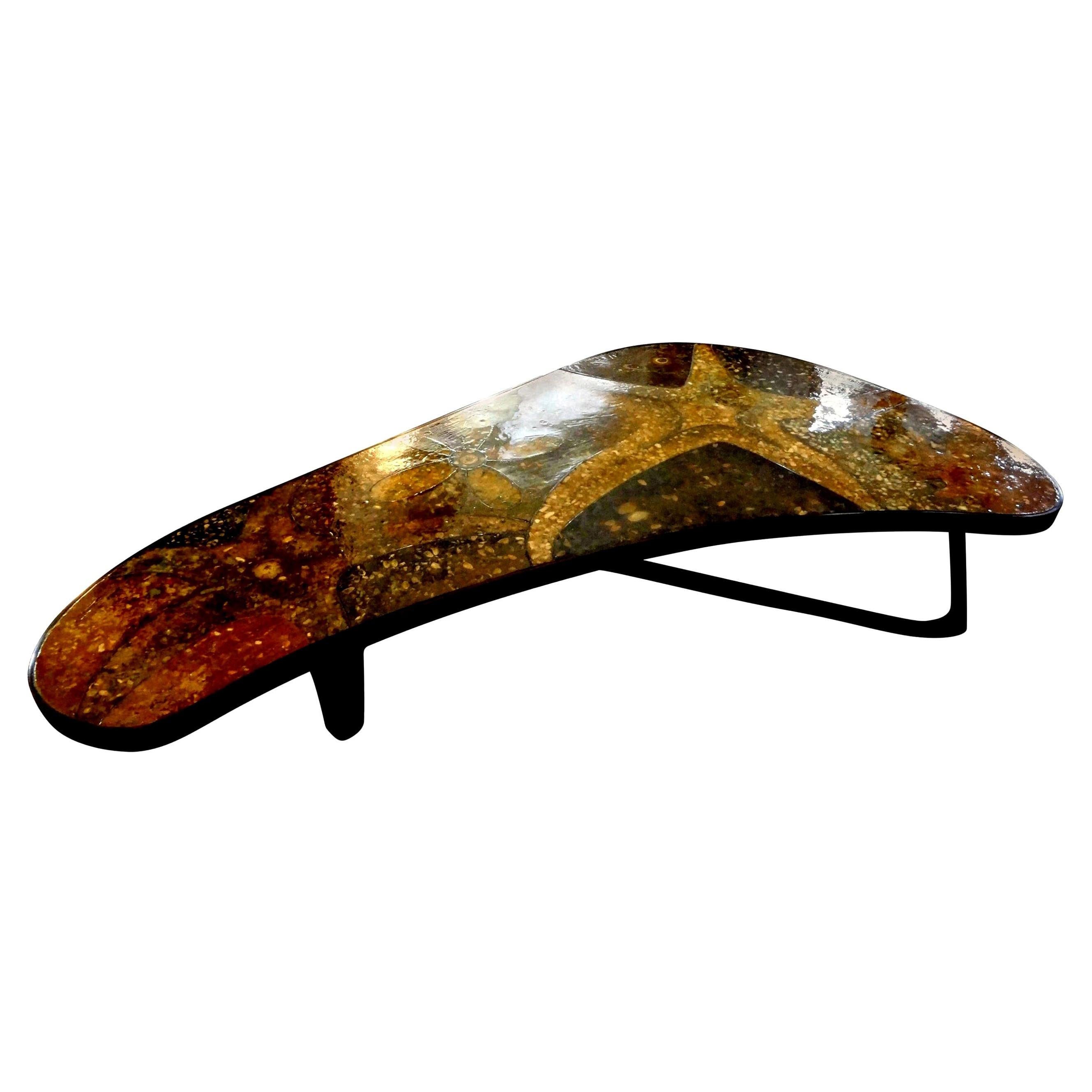 Mid-Century Modern bronze resin and shell cocktail table.
Outstanding custom Mid-Century Modern bronze cocktail table with a resin, shell and stone top. This most unusual large coffee table is boomerang shaped and is in very good condition. This