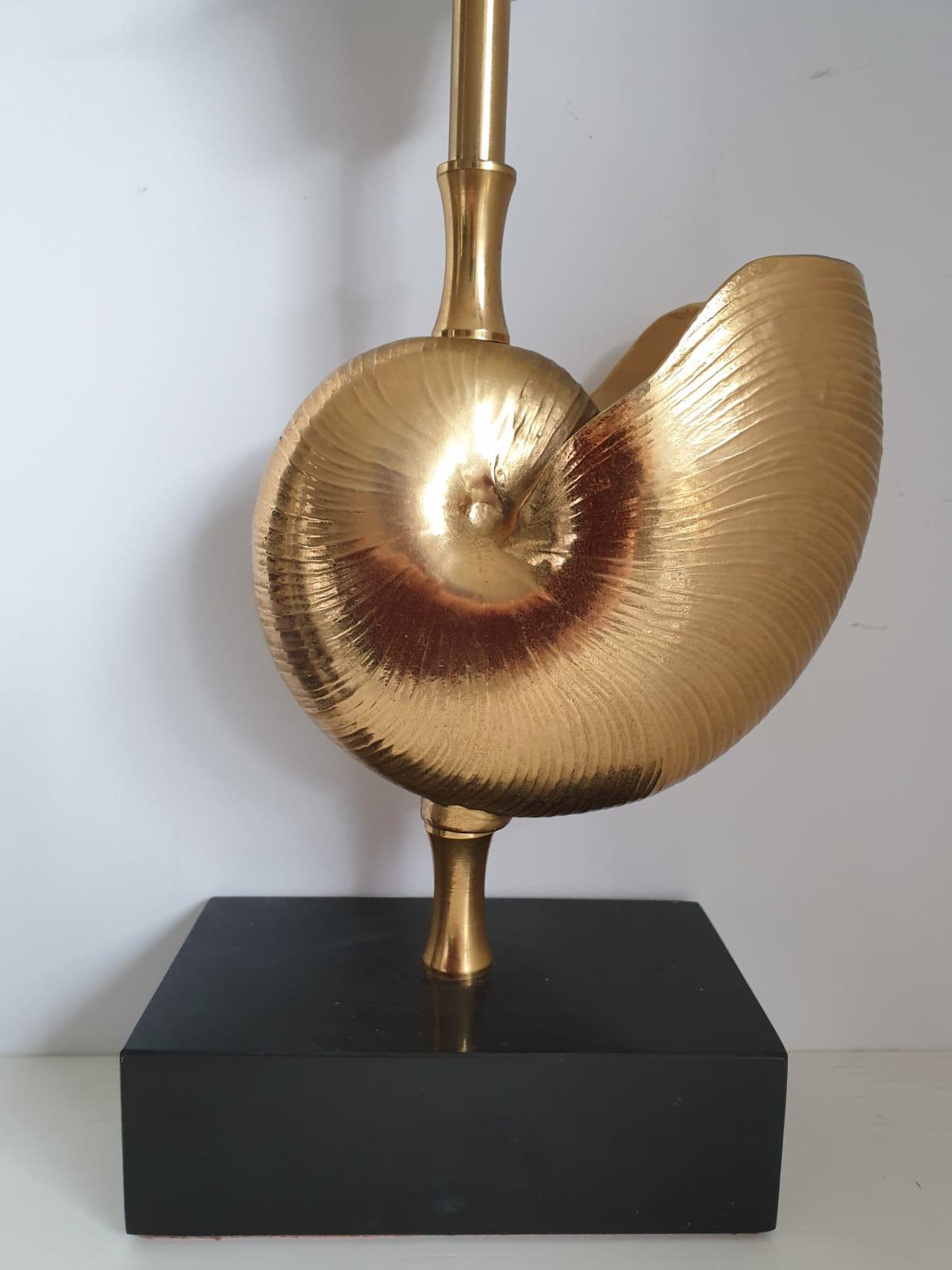 Well sized bronze table lamp with shell design sitting on a marble base.