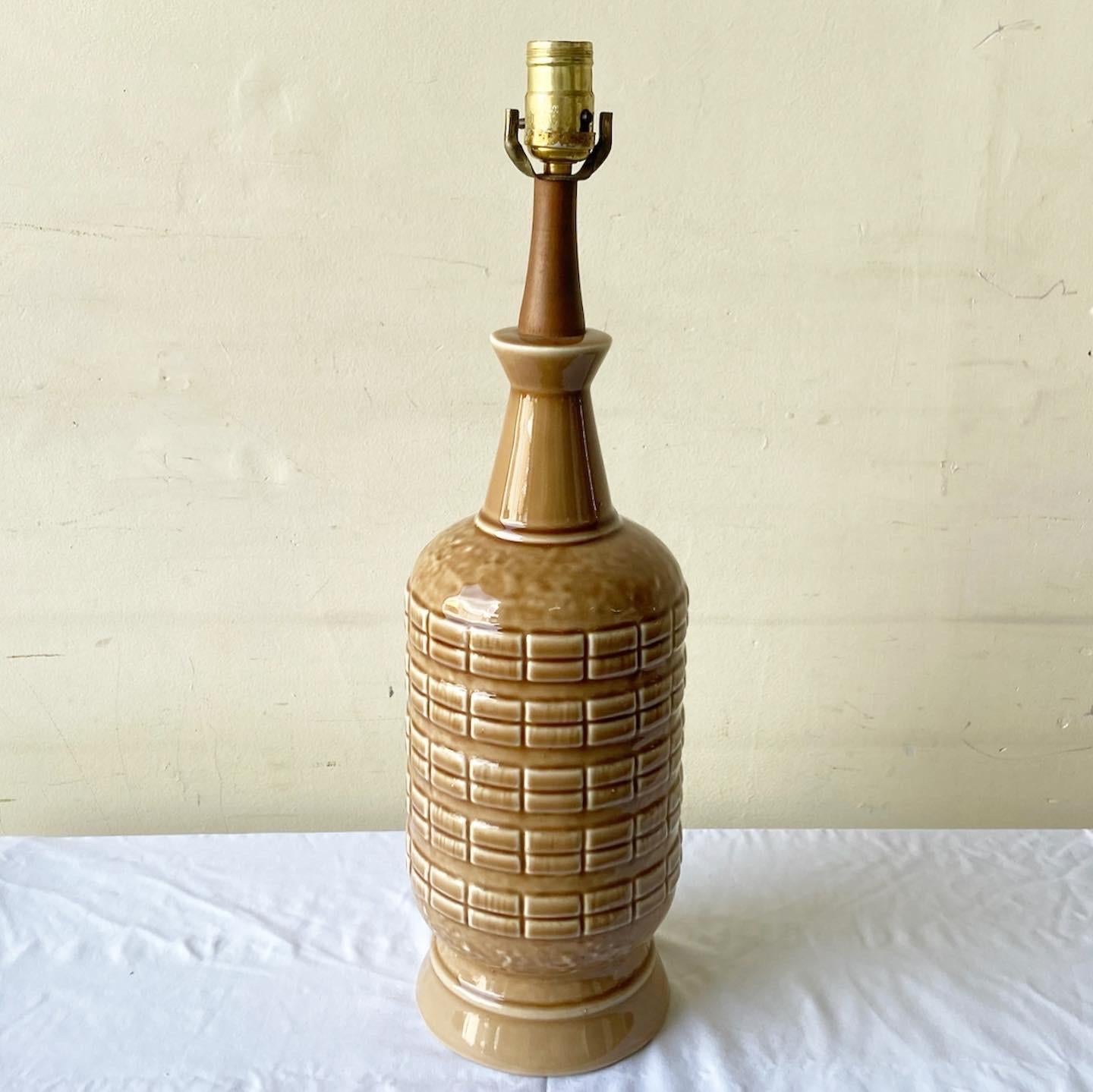Amazing mid century modern table lamp. Features a brown ceramic body with a wooden neck.

Additional information:
Material: Ceramic, Wood
Color: Brown
Style: Postmodern
Time Period: 1960s
Place of origin: USA
Dimension: 6ʺ W × 6ʺ D × 21.5ʺ L