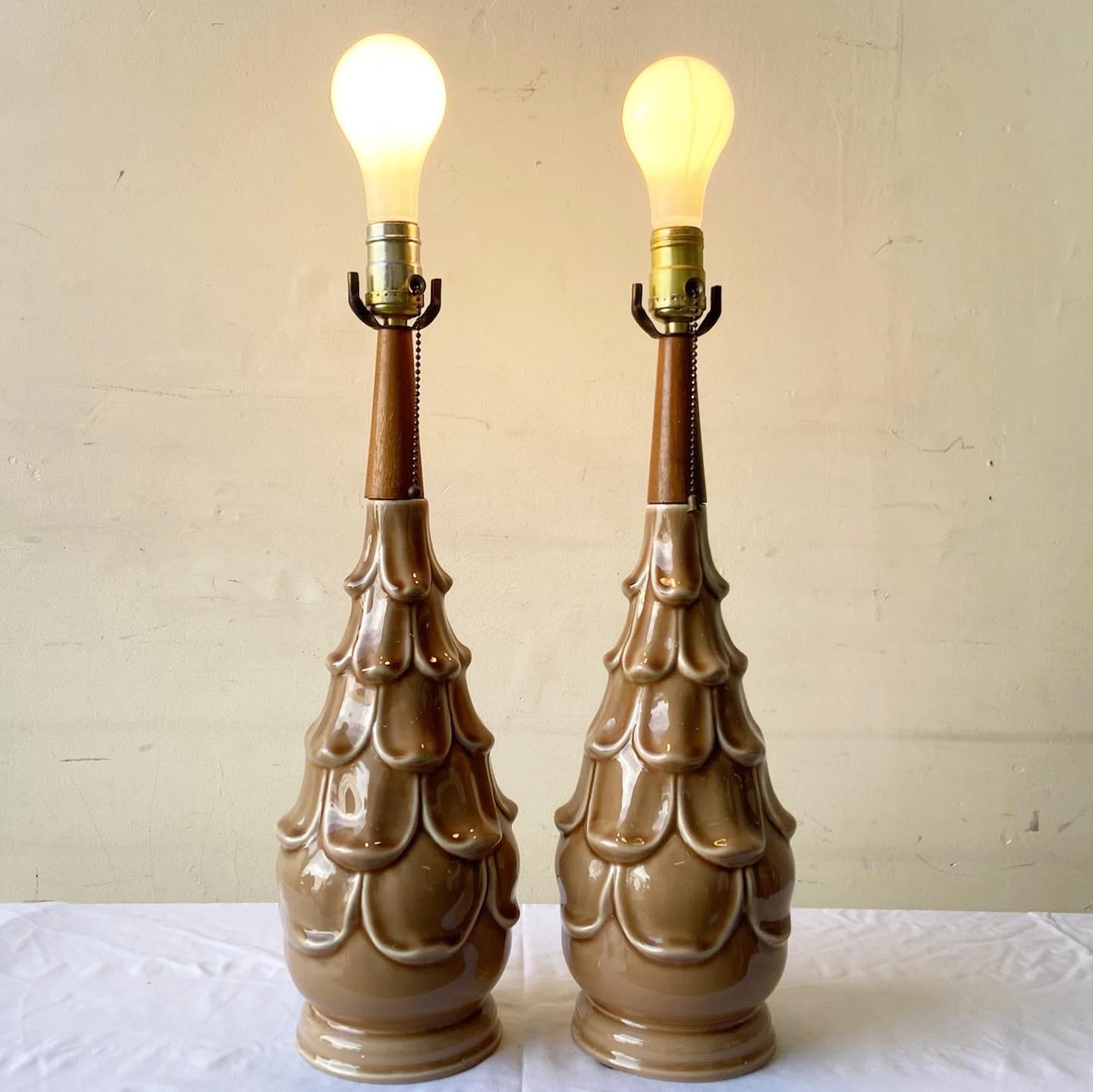 Amazing mid century modern pair of table lamps. Each feature a wooden neck with a sculpted brown ceramic body.
