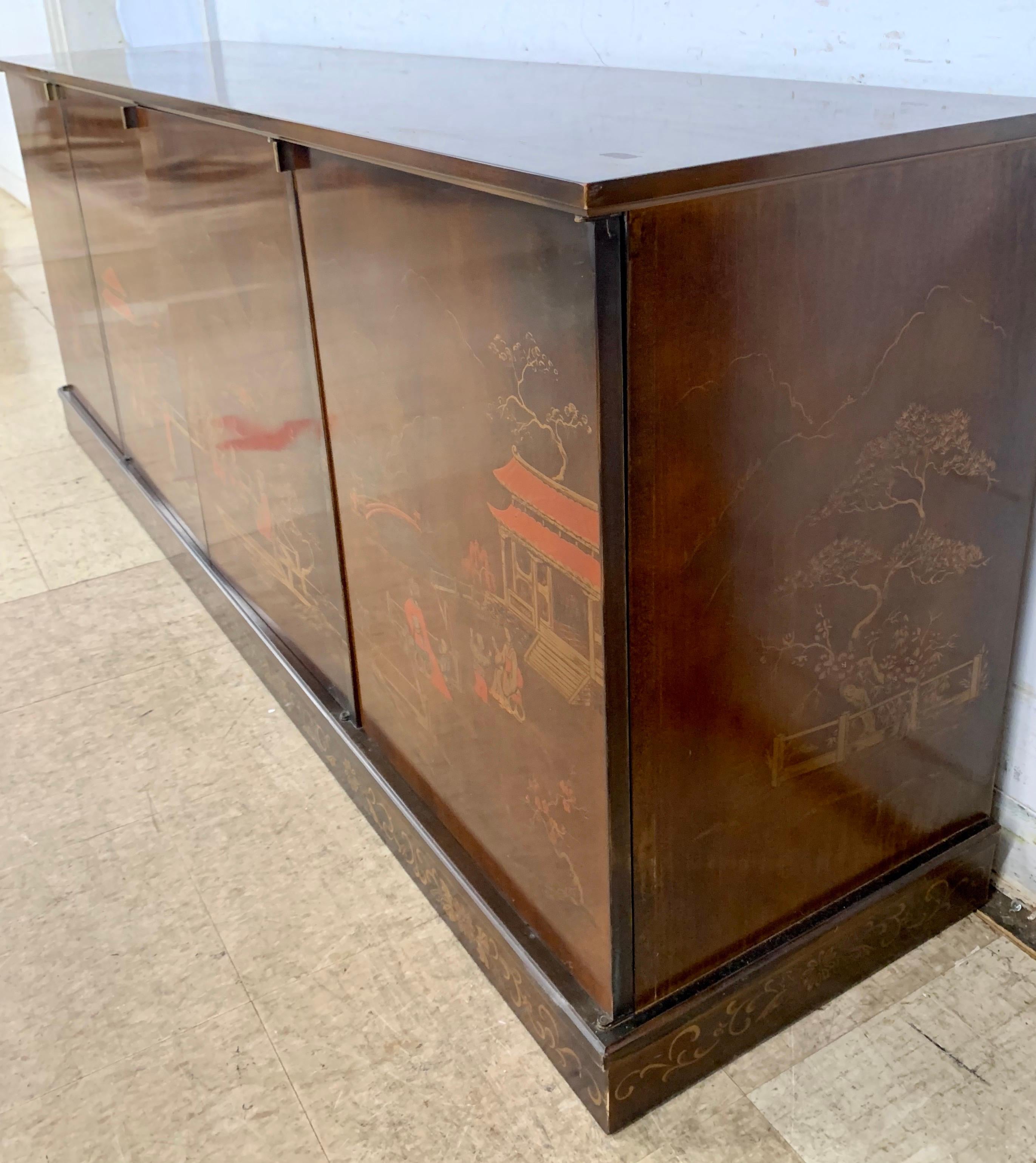 The ultimate Mid-Century Modern Chinoiserie multi-purpose credenza with handpainted scenery on the front and sides. Now, more than ever, home is where the heart is. Circa 1970's. All wood, looks to be mahogany. They don't make them like this anymore.
