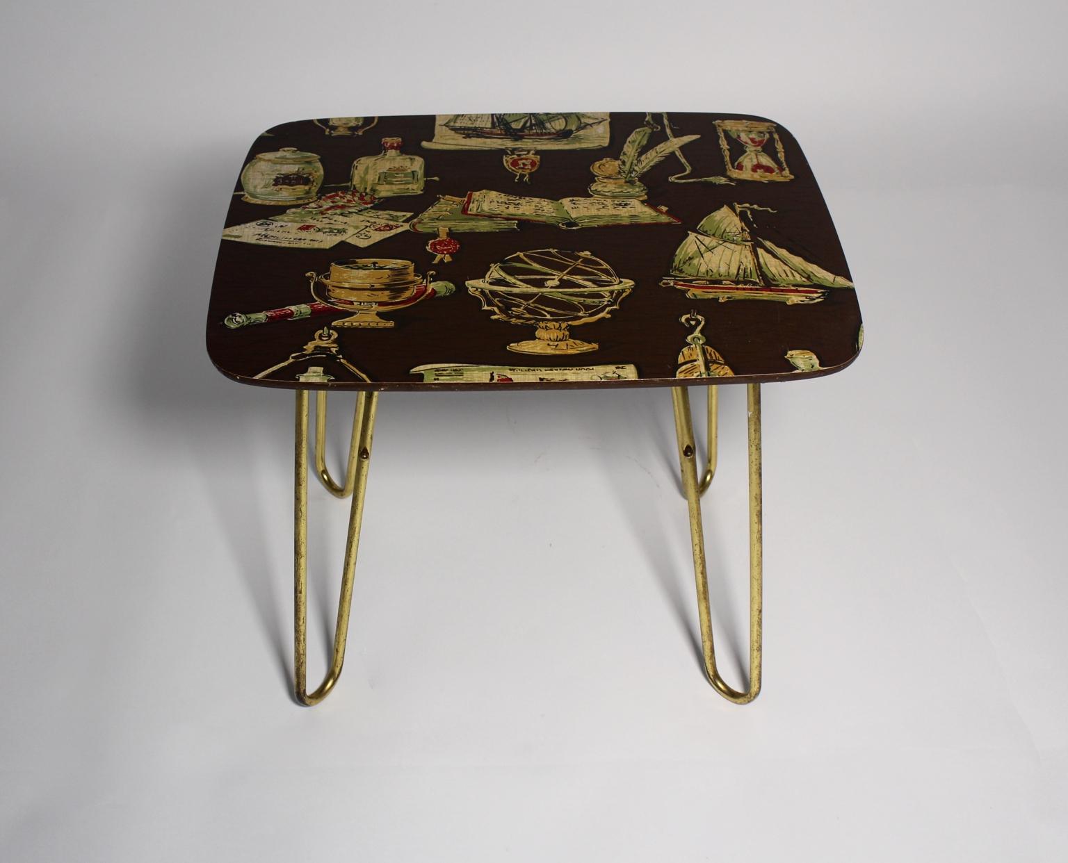 This presented coffee table features hairpin curved brass feet, furthermore a brown lacquered tabletop with various motif prints.
The original condition is very good with signs of age and use.
The brass feet show great brass patina.

approx.