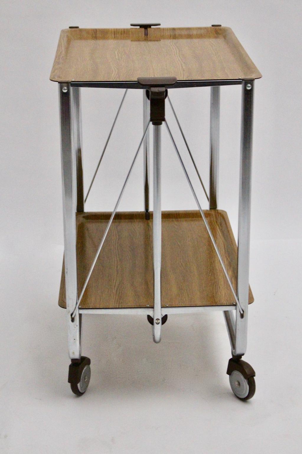 This foldable serving table from the 1960s era features a chromed base with two tiers and four wheels.
The serving table consists of chromed metal and plastic.
The vintage condition is very good.

approx. measures:
Width 69 cm
Depth 41.5 cm
Height