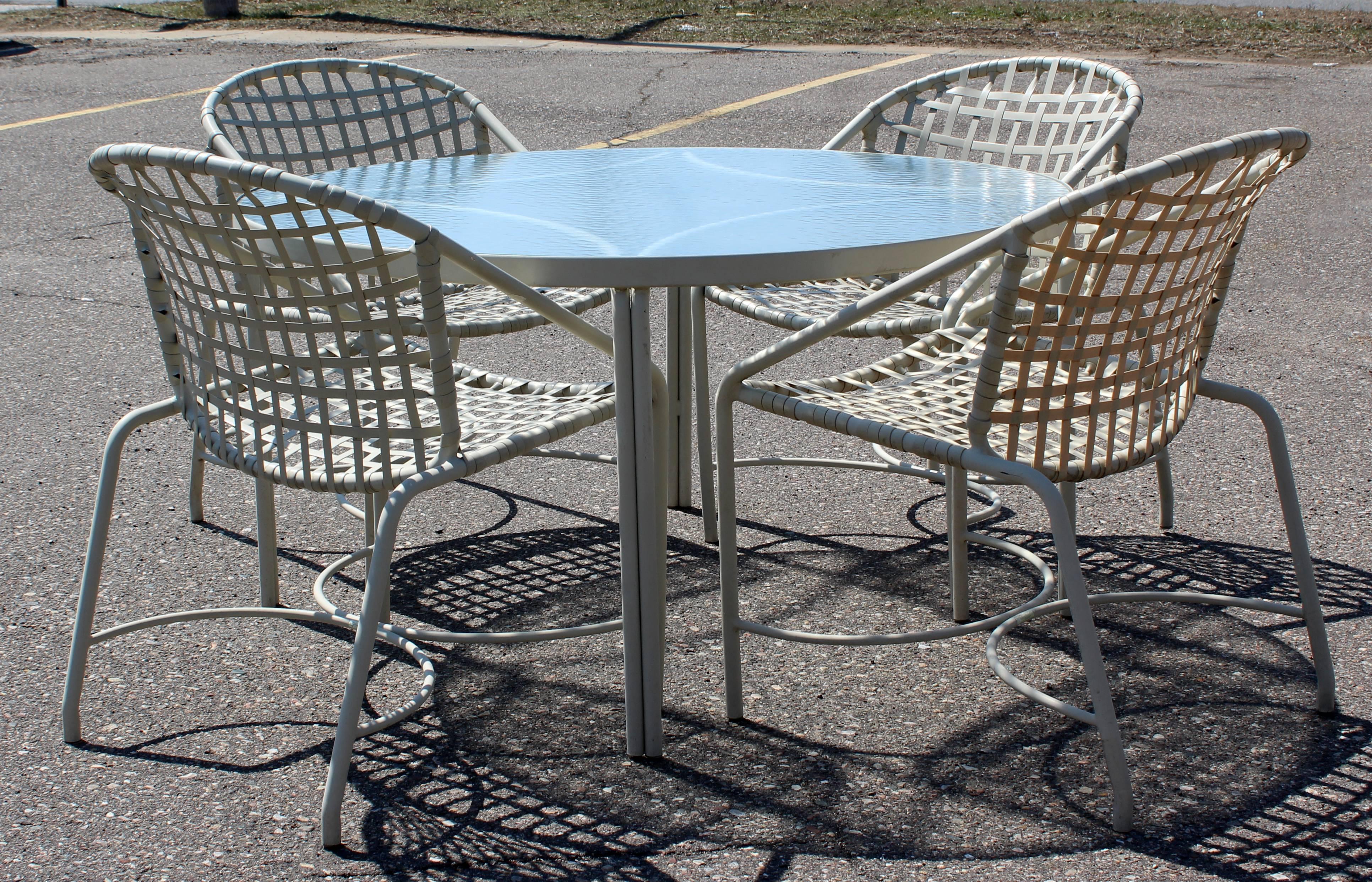 For your consideration is an outdoor patio dining set, including a table with a glass top and four chairs, by Brown Jordan the Kantan series, circa 1960s. In excellent condition. The dimensions of the table are 47