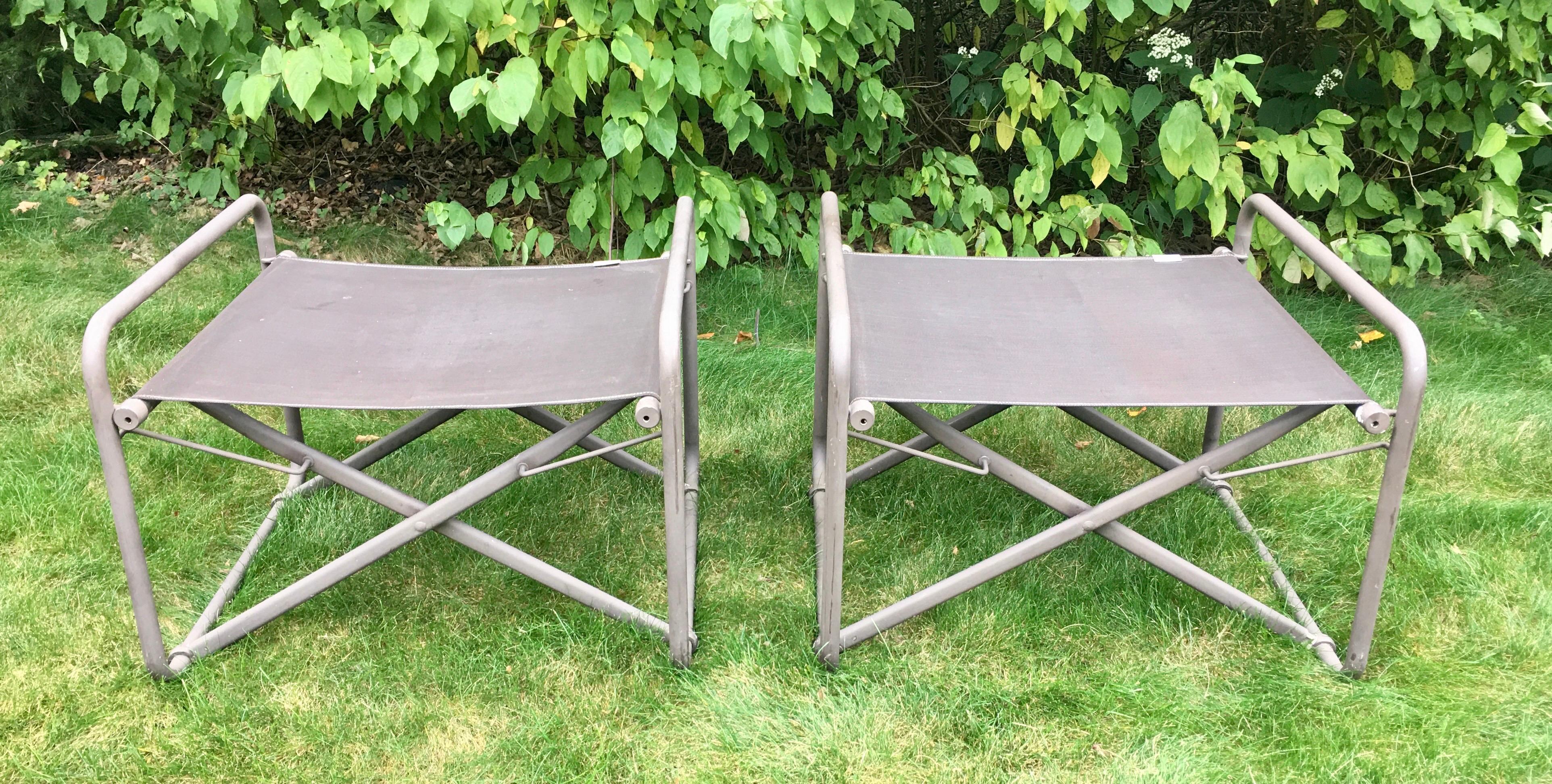 Pair of sculptural Mid-Century Modern Brown Jordan Original Nomad collection ottomans, circa 1970s. Features original brown colored powder-coated aluminum/metal frames with brown mesh fabric. These folding Campaign style benches can be used as