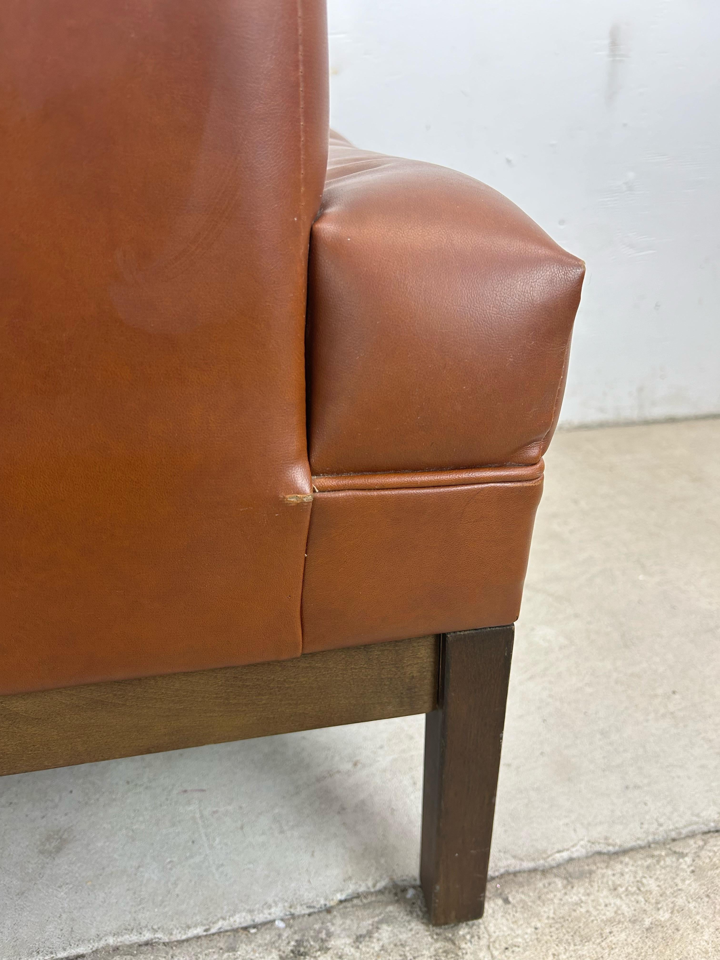 Cette chaise de salon moderne du milieu du siècle présente un revêtement en vinyle marron avec une assise et un dossier touffetés sur une base en noyer massif.

Dimensions : 28.5w 31d 31h 17.5sh 23.75ah

Condit : La sellerie vinyle d'origine est en