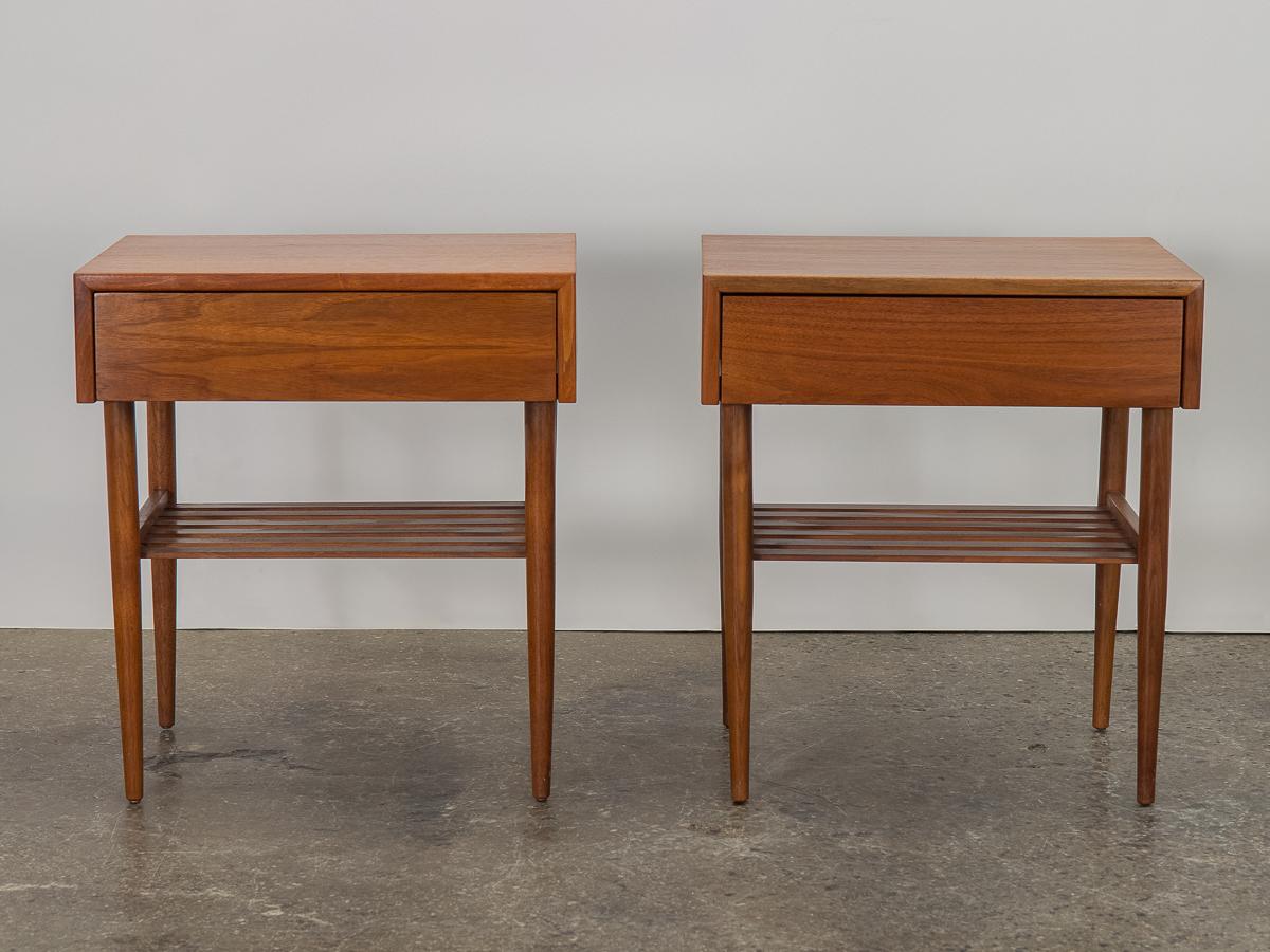 Pair of handsome Mid-Century Modern nightstands, designed by John Keal for Brown Saltman. Sleek and minimal profile, with finely tapered legs. Rich mahogany wood selection is gleaming and has been freshly polished. A wonderful storage solution,