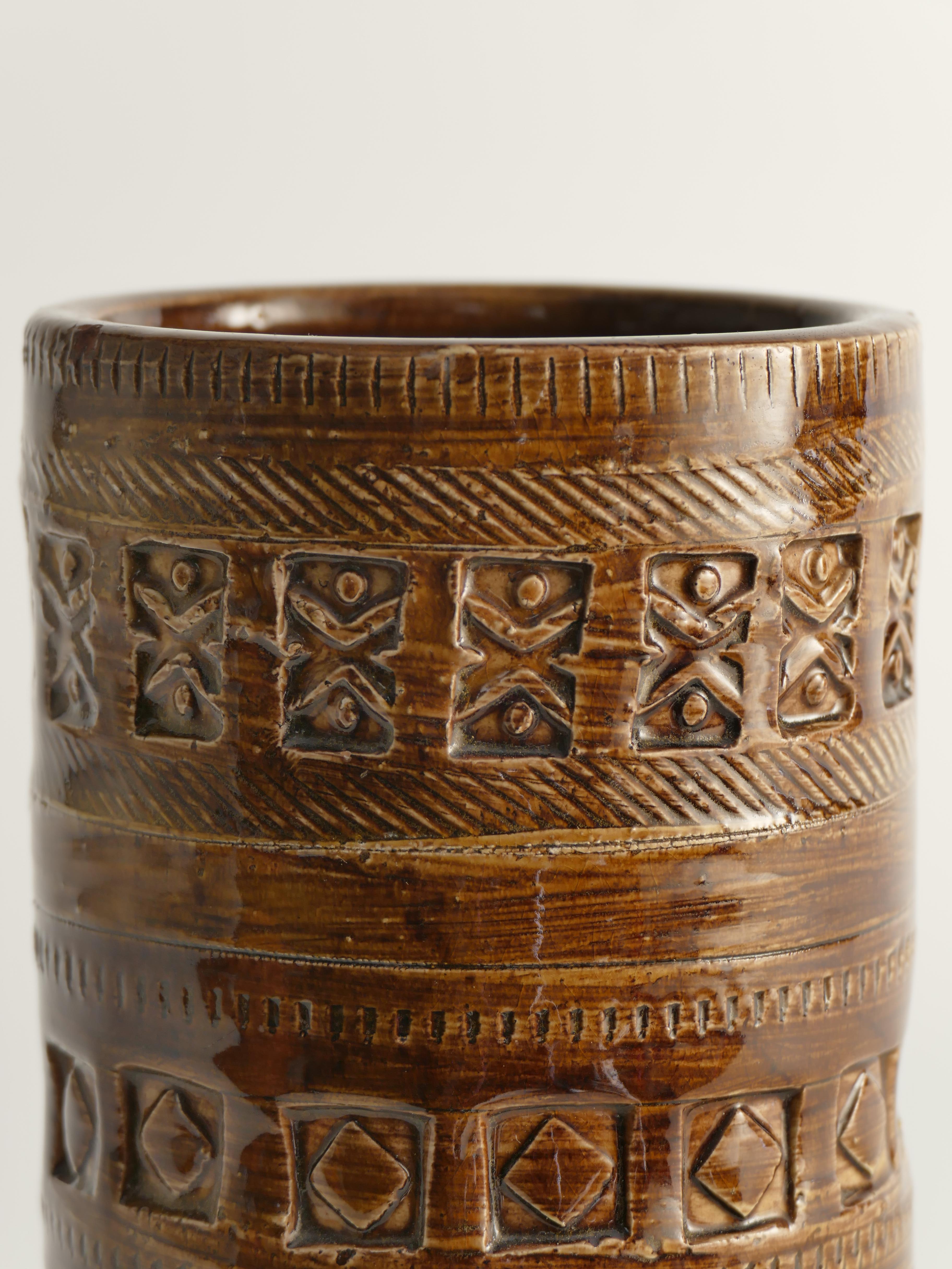 Questo vaso in gres, realizzato da Aldo Londi e prodotto da Bitossi in Italia negli anni Sessanta, presenta una sorprendente tonalità marrone ornata da accenti di marrone chiaro e intricati disegni geometrici incisi. 

Questo pezzo si distingue per