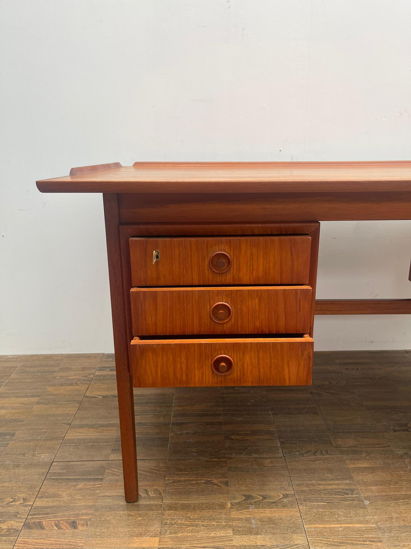 Mid-Century Modern brown teak desk with drawers.

