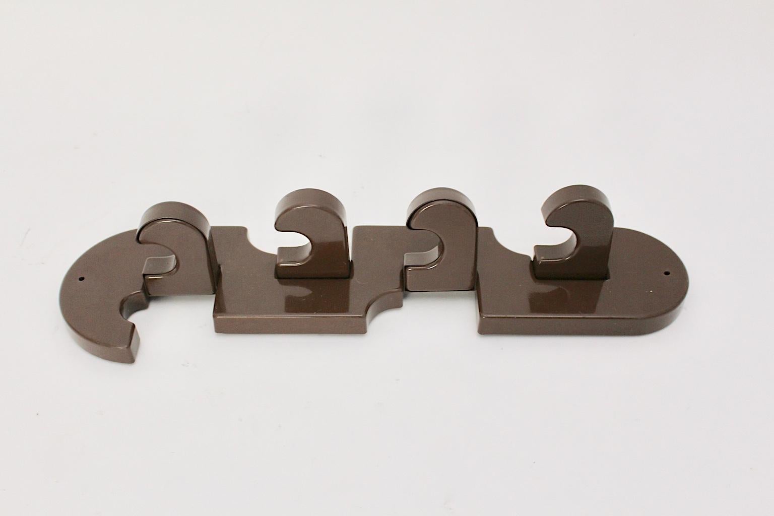 The Mid-Century Modern wall-mounted chocolate brown vintage plastic coat rack was made in 1970 in the middle of Europe, in Milano, Italy according the paper label back-faced the coat hook.
Furthermore the wall coat rack features 4 foldable