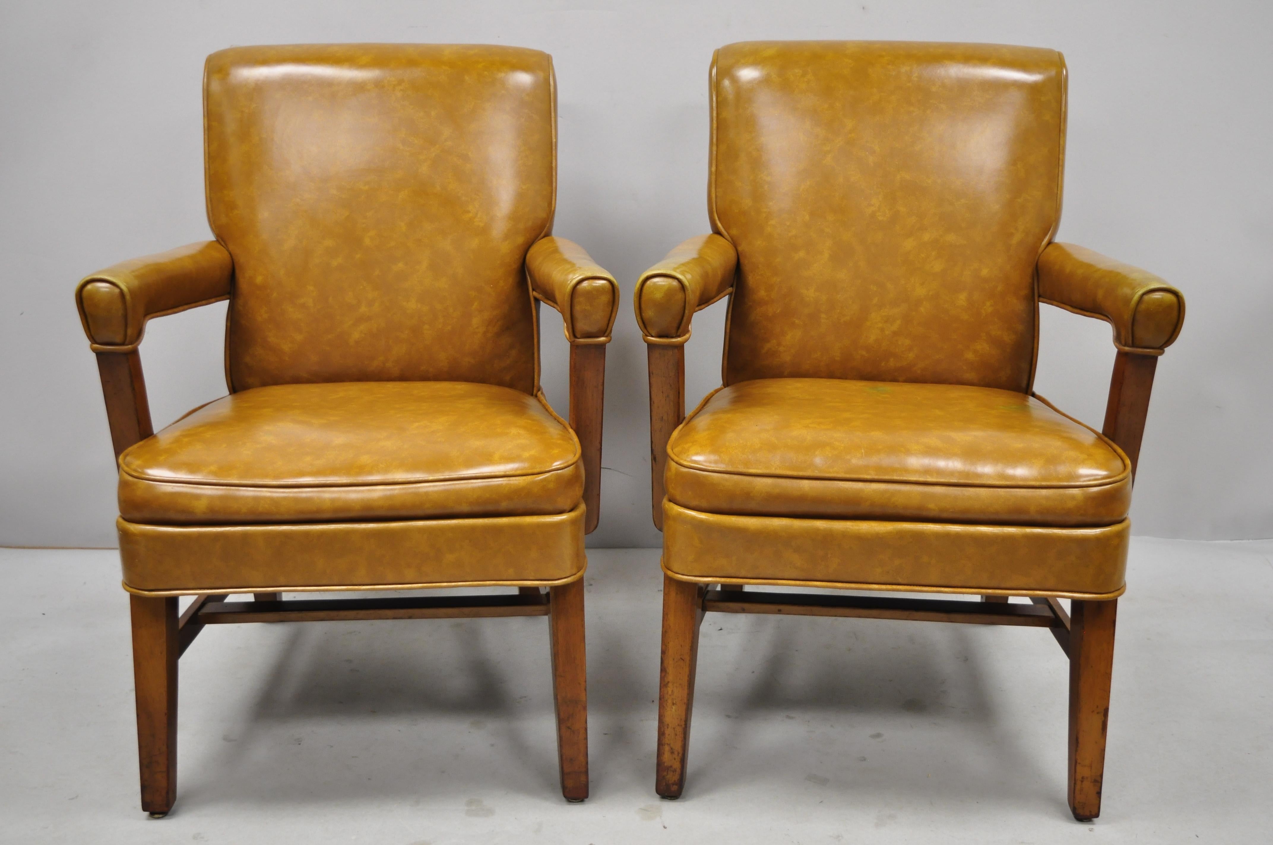 Mid-Century Modern brown vinyl sculpted wood office library armchairs - a pair. Item features solid wood frames, brown vinyl wrapped upholstery, upholstered armrests, sleek sculptural form, tapered legs, clean modernist lines, quality American