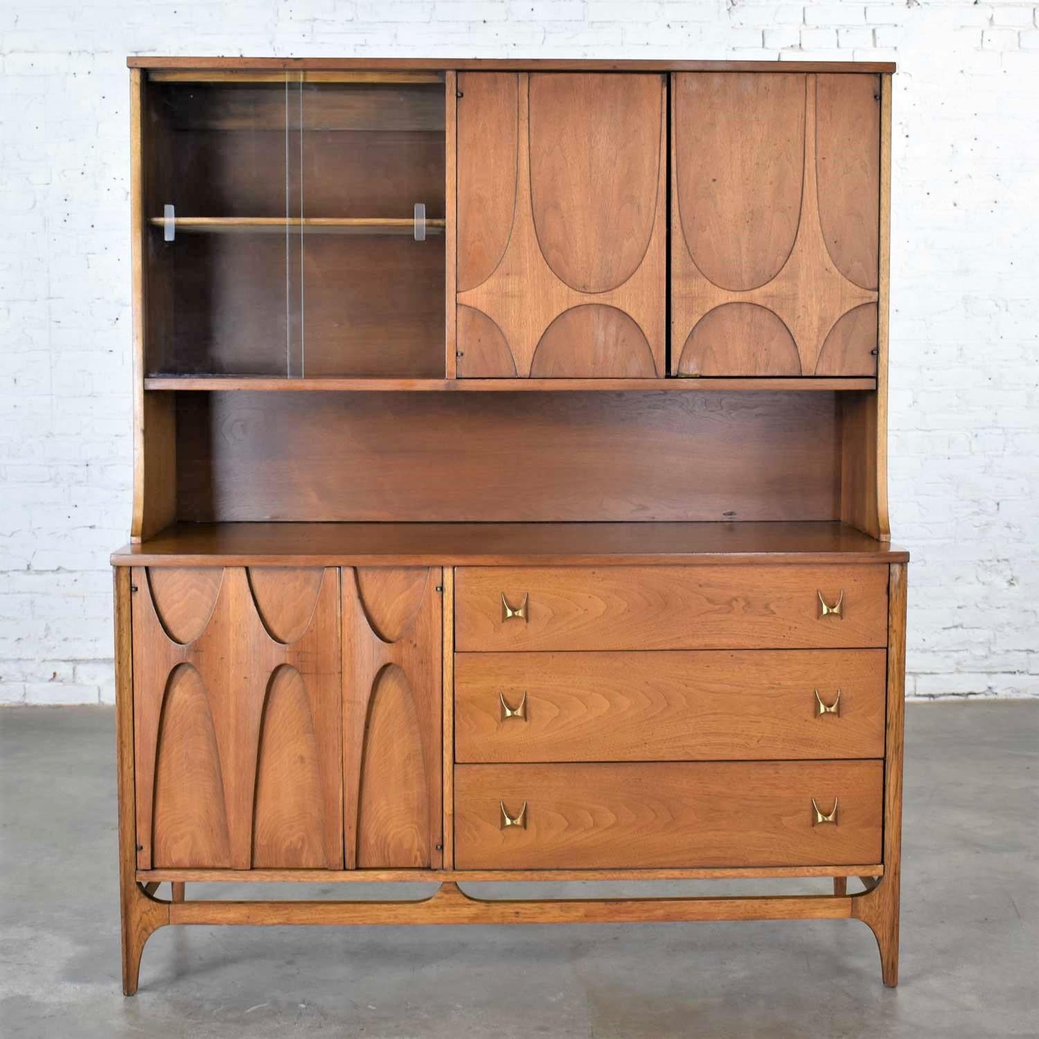 Handsome Broyhill Brasilia Mid-Century Modern two-piece walnut display cabinet consisting of buffet with detachable china hutch. It is in good vintage condition. It is not perfect. We have restored the finish but have not refinished this cabinet. We