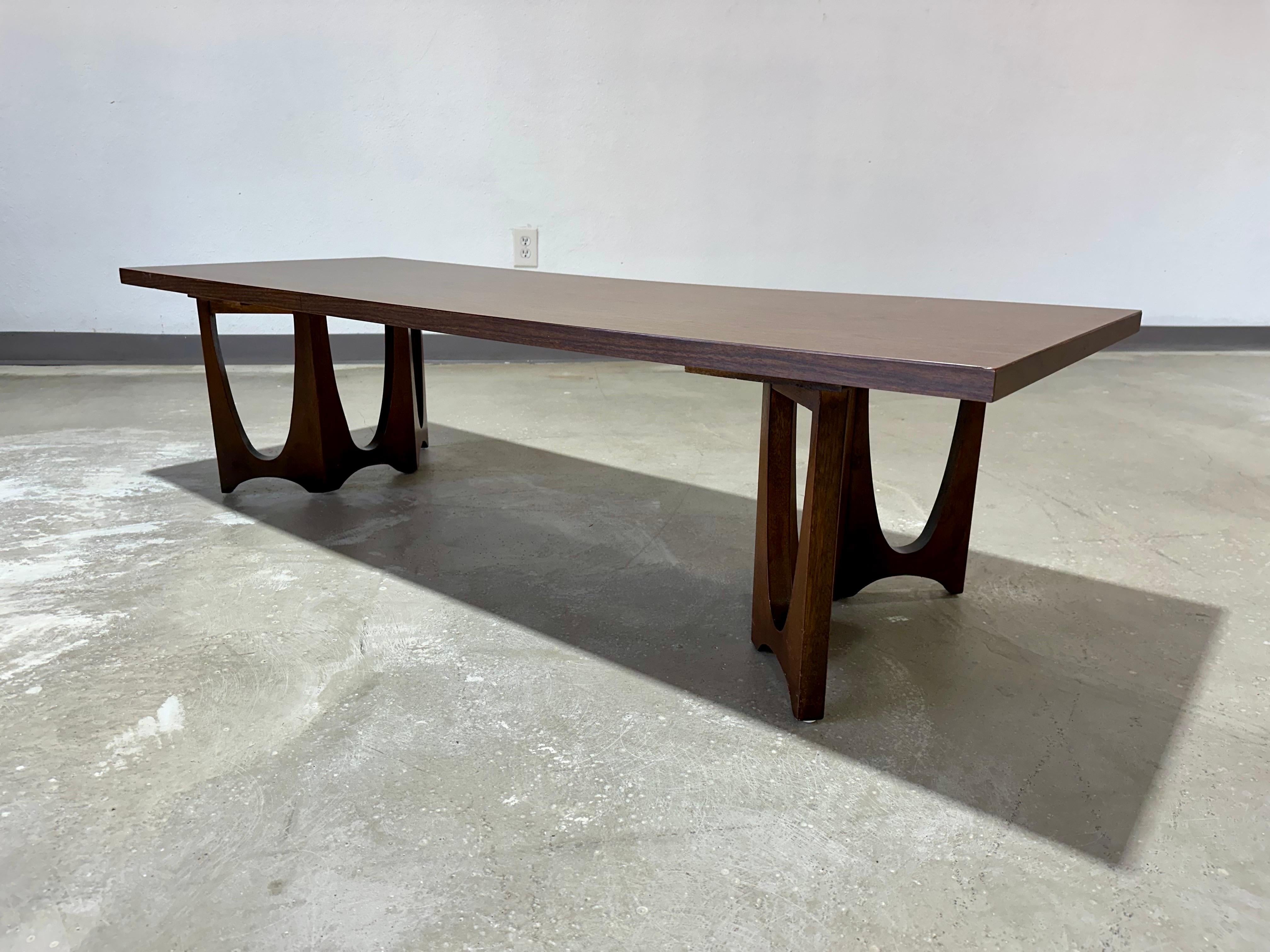 Mid Century Modern Broyhill Brasilia Coffee/Cocktail Table, rectangular laminate top with iconic Brasilia legs in walnut. Overall great original vintage condition with minimal age appropriate wear. Dimensions: 60”L x 22”W x 16”H
