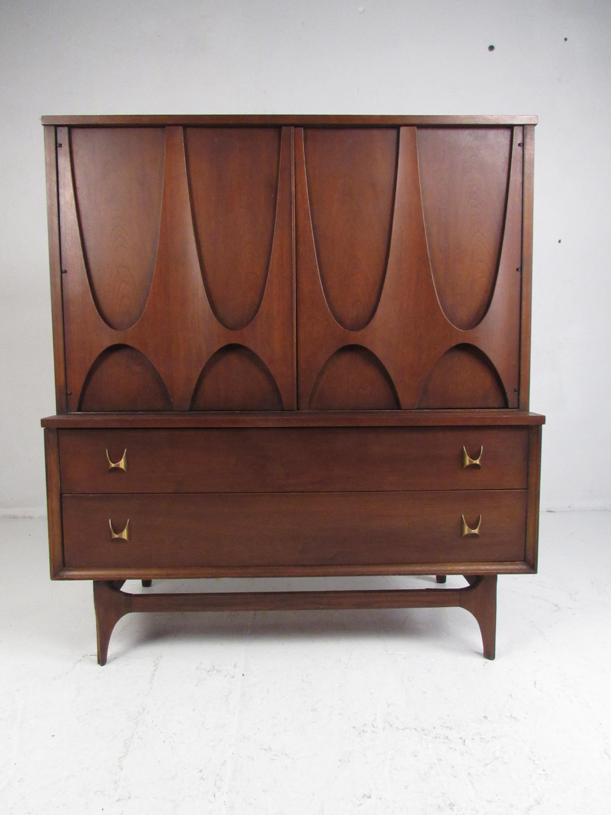 This elegant vintage modern dresser features a Brutalist front, splayed legs, and sculpted brass drawer pulls. A versatile design that offers plenty of room for storage within its many drawers and compartments. The unusual sculpted cabinet pulls and